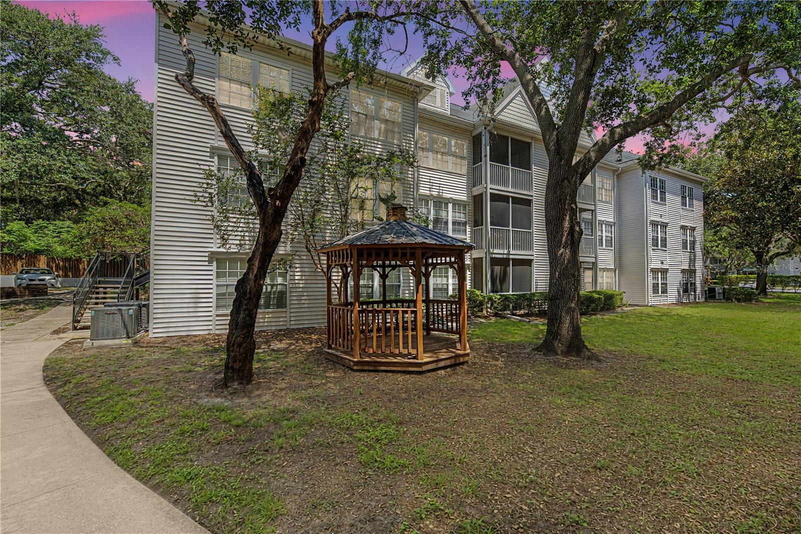 Welcome to elevated living in the maintenance free gated community of Bentley at Cobbs Landing! This beautifully remodeled 3-bedroom, 2-bath condo with an expansive upstairs loft plus 1 covered carport space (these are a hot commodity) is turnkey ready for its next owner. The home showcases new wood-look flooring throughout and a stunning redesigned kitchen with quartz countertops, stainless steel appliances, new shaker style cabinetry, and sleek modern finishes. Enter into a beautiful foyer, a perfect space to come home to as well as greet guests. Travel up a flight of stairs and enter the spacious wide-open living, kitchen and dining areas, which flow effortlessly to the private balcony, creating an inviting setting for both everyday living and entertaining. A large storage closet, new washer and dryer, updated air-conditioning system, and fully re-piped plumbing add convenience and peace of mind. The desirable split-bedroom floor plan offers privacy and functionality. The spacious primary suite features a generous walk-in closet and a beautifully remodeled ensuite bathroom with a walk-in shower, quartz-topped vanity, and refined finishes. Two additional bedrooms are located on the opposite side of the home and share an equally stylish second bathroom with a tub-and-shower combination, quartz countertop, single vanity, and linen closet. Upstairs, the oversized loft offers exceptional flexibility and is ideal for a bonus room, home office, guest retreat, or office-and-bedroom combination. Residents enjoy an impressive collection of amenities, including a resort-style pool and spa, fitness center, clubhouse, library, BBQ area, playground, dog-walking areas, vehicle storage, and a convenient car wash station, all surrounded by beautifully maintained grounds. The association provides the ease of true low-maintenance living, with services that include exterior maintenance, roof coverage, grounds upkeep, trash, cable, and internet. Recent community improvements include updated roofs, siding, and exterior paint. Ideally located in Palm Harbor near highly regarded schools, shopping, dining, sports facilities, award-winning golf, beaches, and Tampa International Airport, this move-in-ready residence delivers style, comfort, and an exceptional Florida lifestyle.