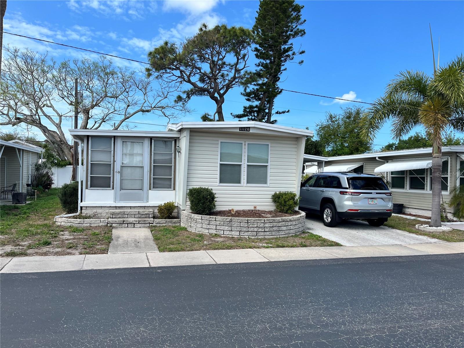 VOTED #1 MOBILE HOME PARK IN LARGO FOR 2025! Welcome to this well-maintained 2-bedroom, 1-bath mobile home located in the highly sought-after Lake Seminole Resort, a 55+ resident-owned community. This charming home features a spacious bonus room, perfect for relaxing or entertaining, and a covered carport with a cozy sitting area. Enjoy an active Florida lifestyle with a long list of community amenities, including lakefront access, a fishing pier, boat docks and boat storage, shuffleboard courts, a clubhouse, heated in-ground pool and hot tub, library, pavilion, outdoor showers and restrooms, a community laundry room, and a full calendar of resident activities. Bring your kayak, wave runner, fishing gear, to relax and enjoy living right on the popular beautiful large lake. Whether you're looking for a full-time residence or a seasonal escape, this home offers it all—just 5 miles from the award-winning Gulf beaches and minutes from local restaurants, shopping, grocery stores, pharmacies, and nightly entertainment. $55,000 land share is included in the price. The home comes furnished and items such as bicycles, power washer, lounge chairs are also included. Move-in ready!