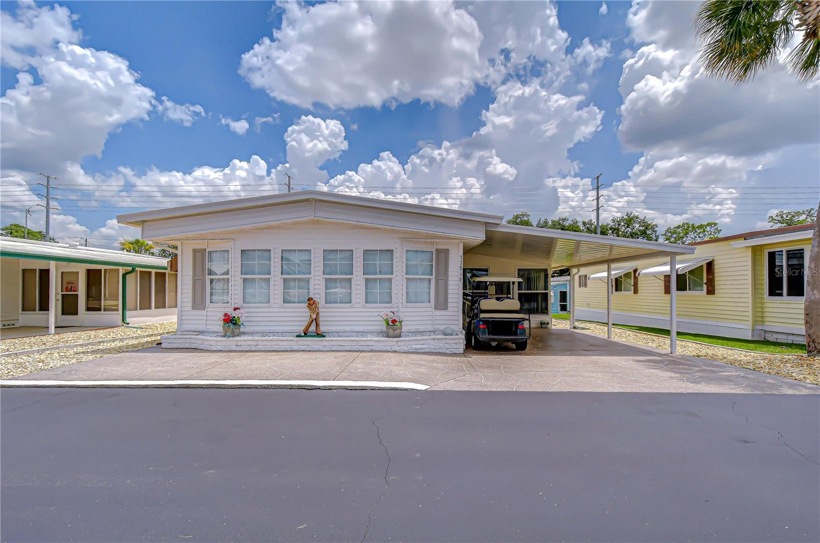 This beautiful 2 bedroom/2 bath double-wide mobile home could be one of the best winter retreats or year-round homes you’ll find in Spanish Trails Village. It has 1,152 sq ft of heated/cooled space in the main home. PLUS, a nicely finished addition connected to the central heat and air-conditioning system. It gives you 190 sq ft of extra space to enjoy and relax in! This home is situated in Spanish Trails Village, a gated 55+ community where one owns the land under the homes. The dwelling has a great layout with easy flow from the living room to the dining room to the kitchen. The main part of the home has wall-to-wall carpeting in the main sections of the home and easy to maintain vinyl laminate flooring in the kitchen and baths. The kitchen has been nicely updated with cabinetry you’ll love and is well organized. Any cook will love creating meals here. The nearby dining room has an attractive built-in cabinet and lots of storage. In the living room you will find plenty of space to entertain family and friends. You can even put up a large, screened television if you like. But the big surprise is that it is just beyond the living room and dining room. There you have a huge 12 ft by 20 ft front room. It is surrounded by windows and gives you lots of options as to how you can use this space. Most homes in the park do not possess this benefit. Both bedrooms have walk-in closets, and the primary bedroom has a full en-suite bath with a large shower. The second bedroom is nearby and so is the second bathroom with its tub/shower. On the west side of the home, besides the addition, you have an extra wide carport where you can park your car and a golf cart. There is also a laundry/storage room and a passageway that leads to a delightful, covered porch on the rear of the home. And most of the windows in the home are double-paned. Your monthly condo fees get you access to the recreation building, swimming pool, whirlpool spa, shuffleboard courts, etc. They even cover your trash pick-up. Pets and golf carts are permitted with some limitations. Located very near restaurants, our hospital, supermarkets, home centers, medical facilities, Walmart, parks, etc. This home is well priced and will garner a lot of attention from buyers. Call today to get more information or arrange a tour!