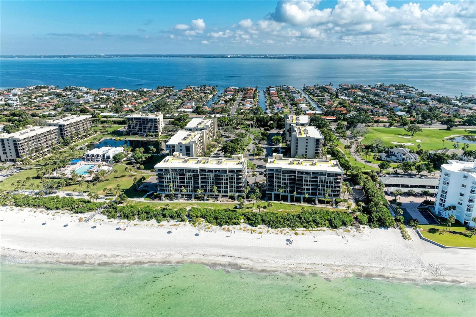 One or more photo(s) has been virtually staged. One or more video(s) was virtually staged. Sunny and rarely available 2-bedroom, 2-bath corner residence in BeachPlace III on Longboat Key. This desirable end unit offers a wraparound terrace and open views of lush tropical landscaping, the Longboat Key Club’s Links Golf Course, and partial Gulf views—providing excellent natural light and a true coastal feel.

The residence features brand-new, impact-rated floor-to-ceiling sliding glass doors that brighten the living and dining areas and enhance indoor-outdoor living. The open-concept layout connects the kitchen, dining, and living spaces, making it well suited for everyday living or entertaining. A split-bedroom floor plan provides privacy, with the primary suite offering direct access to the terrace. One assigned parking space is included, and the unit is ready for personalization or updating. 

BeachPlace is a gated, Gulf-front condominium community offering 24-hour security and resort-style amenities, including a clubhouse, heated beachfront pool and spa, tennis courts, fitness center, and a private boardwalk with direct beach access. Seasonal beach service with lounge chairs and umbrellas is provided.

Conveniently located near golf, marinas, dining, and shopping, and just a short drive to downtown Sarasota, this property offers flexibility as a full-time residence, seasonal getaway, or investment opportunity.