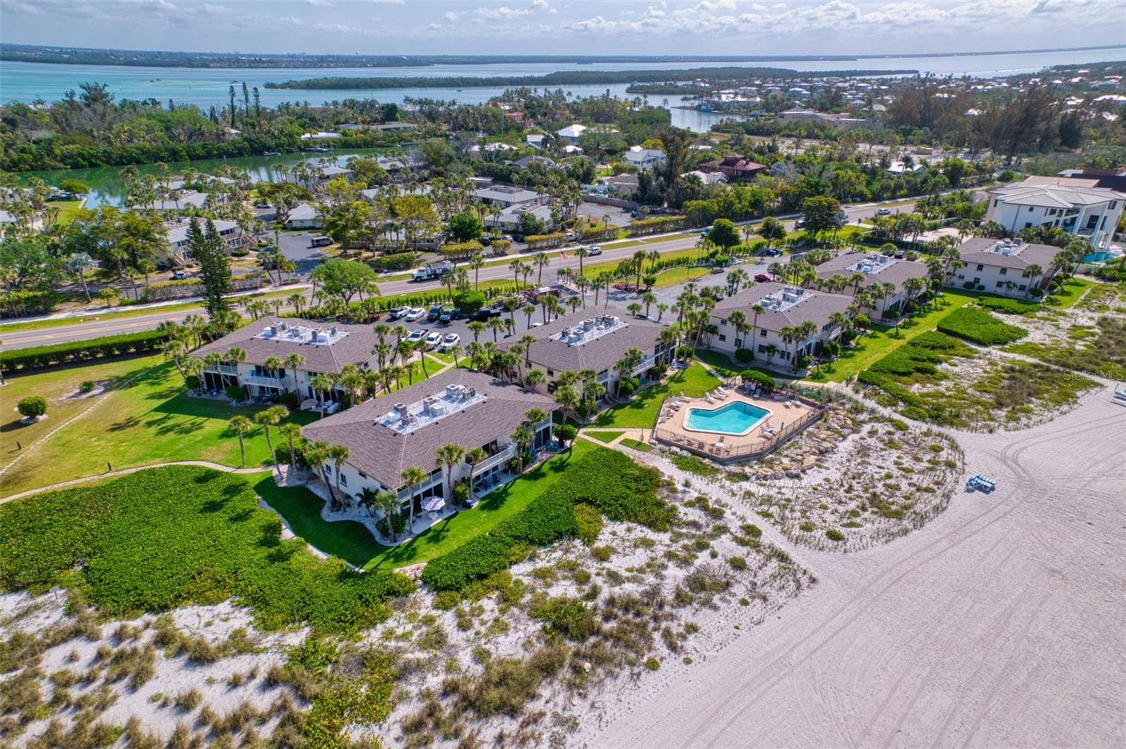 Finally, you have the opportunity to own your own "Walk-Out", Gulf Front, Beach Condo. Tucked just behind a beach grass sand dune and situated on a grassy knoll, this unit is perfectly positioned to benefit from refreshing sea breezes while offering spectacular sunset views. This rare one-bedroom condo has been completely remodeled and now features a unique two-bathroom floorplan. Remodeled Interior and Modern Upgrades:  The spacious living area boasts premium appliances and upgraded stone countertops on new cabinetry within a newly designed open kitchen. Updates abound throughout the unit: new hurricane impact resistant sliding doors and a front window, along with modern bathrooms. The property is being sold turn-key—everything stays, making it a seamless move-in experience.  Step inside and discover a bright, inviting interior with an open, light-filled layout designed to maximize both space and natural beauty. Large glass sliders connect the interior to the outdoors, bathing the kitchen and living area in sunlight and blending innovative functionality with coastal charm. The thoughtfully designed bedroom and bathrooms provide serene retreats, perfectly balancing comfort and style.  Private Outdoor Oasis:  The unique ground floor “Whitney Beach Gulfside” floorplan offers both a front privacy-fenced enclosed patio—ideal for alfresco dining or beachfront gardening—and a rear open patio for relaxation. Whether enjoying a quiet morning coffee or an evening cocktail, the gentle sea breeze creates the perfect setting for unwinding.  Resort-Style Community Amenities: Enhance your lifestyle with a range of well-maintained community amenities, including a sparkling pool, tennis courts, shuffleboard, beach chairs, boat slips available for lease, and a tranquil pavilion by the bayou for water enthusiasts. Unmatched Location and Lifestyle: Experience the best of coastal living on Longboat Key. Whitney Beach is located on the quiet, northern end of Longboat Key, close to fantastic restaurants, shops, and shopping—just steps away, an easy bike ride, or a short drive to visit St Armands Circle.
This condo combines a highly desirable location with the privacy and comfort of a casual beachfront lifestyle—perfect for year-round living, a seasonal retreat, or a smart investment. With one-month minimum rentals allowed up to 12 times per year, the property offers excellent investment potential. BONUS:  the community features two-story buildings and is exempt from Florida’s Milestone inspection and reporting requirements, ensuring a NO SURPRISE experience. Discover Longboat Key:  Enjoy the finest Longboat Key has to offer, where luxury meets laid-back coastal charm. Schedule your private tour today!
