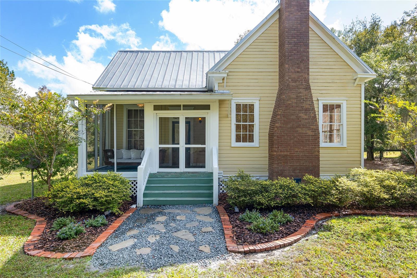 Step into your own piece of history with this charming updated chic cottage style home in the historic Micanopy that is nestled on nearly 5 acres of picturesque land, all fenced in for horses if desired. This breathtaking spectacular home offers an abundance of endless charms, for those with love for a nostalgic, vintage Southern charm, this is your home. 

As soon as you enter the screened in porch, you will be welcomed by a cozy custom made wood lounge bed swing perfect for snuggling on cool fall evenings, you will be captivated by the southern charm and the seamless blend of vintage meets modern amenities. With over 1400 square feet of living space, this 2 bedroom, 2 bath home offers plenty of room to grow which ultimately will create the home of your dreams.

The barn-like train depot is included as a bonus with this purchase, opens up a world of possibilities. Imagine transforming it into a guest house, art studio, or even a workshop - the choice is yours!

But it's not just the potential that makes this property special. The attention to detail is evident throughout, from the high ceilings, stunning molding design, remodeled kitchen with custom stamped tin kitchen ceiling to the farmhouse sinks. The natural wood flooring and brick fireplace add a touch of warmth and character, making you feel right at home.

In addition to the charming interior, the exterior is a true oasis. Step outside to the stone fire pit and enjoy the tranquility of the expansive land, complete with a chicken coop for those with a green thumb or a yearning for farm-fresh eggs.

Located in the historical town of Micanopy, you'll have the best of both worlds - a peaceful retreat away from the hustle and bustle, yet conveniently close to UF and all that Gainesville has to offer.

Don't miss out on this incredible opportunity to own a piece of history. Schedule your private showing today and let your imagination run wild with the endless possibilities that await you in this scenic farmhouse chic cottage. But be quick, because this unique gem won't be available for long!