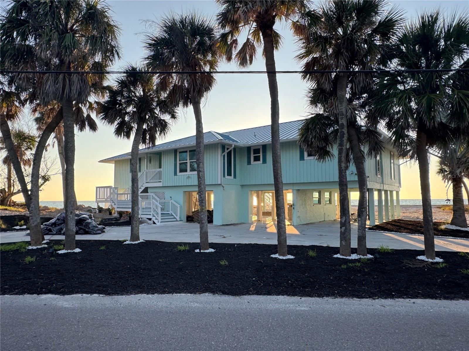Wake up to the sound of the Gulf and step directly onto your balcony from the primary suite, where French doors frame expansive water views. This elevated Manasota Key residence offers a rare blend of openness, tranquility, and effortless coastal living, with approximately 134 feet of frontage along a walkable, sandy beach.Inside, the home has been updated with a clean, modern coastal aesthetic that feels both current and timeless. Vaulted ceilings and an open great-room layout create a bright, airy atmosphere designed around the views, while the kitchen and dining area feature quartz countertops and flow seamlessly into the living space—ideal for entertaining or simply enjoying the rhythm of the shoreline. French doors throughout connect indoor living to the expansive Gulf-view balcony, perfect for morning coffee, taking in Gulf sunsets, or evenings under the stars.The primary suite is a true retreat, featuring direct balcony access, a spa-inspired ensuite bath with walk-in shower and soaking tub, and two walk-in closets designed for everyday comfort. A Gulf-front guest bedroom also enjoys water views, offering guests the same connection to sand and sea. Covered parking beneath the home includes a convenient ground-level bath with shower—perfect after a day at the beach.As an added bonus, the property includes a deeded pedestrian easement providing access to the bay. This is relaxed island living at its best, where days are shaped by tides, light, sea air, and a home that’s ready to be enjoyed today.