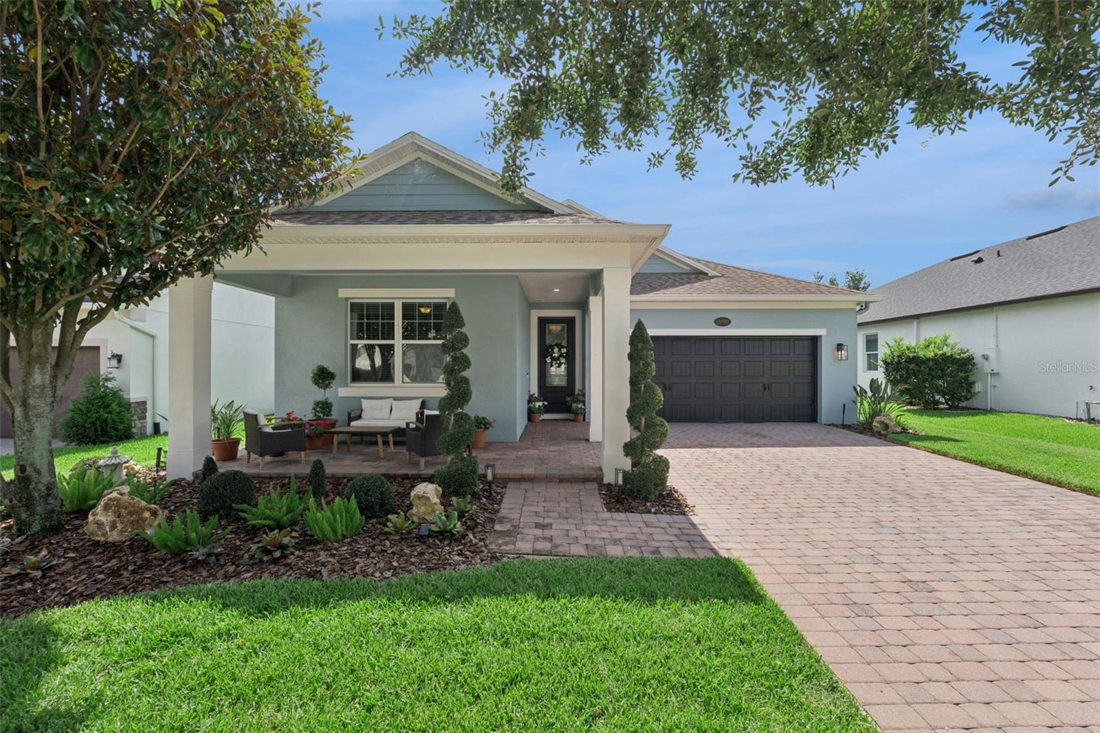 SHOW STOPPER! Welcome to 15587 Hamlin Blossom - in the highly sought-after gated community of HICKORY HAMMOCK. A rare find, this Ashford model by M/I Homes is one of only six Ashford floor plans built in the community. Every detail of the 1860 sq. ft has been thoughtfully designed and meticulously cared-for, creating a TURNKEY experience unlike any other. 
Start off on your paver driveway and enjoy the handpicked lush new landscaping and welcoming porch-sitting area where you can immediately enjoy the outdoor Florida lifestyle. NEW EXTERIOR PAINT. Once inside you are greeted with perfection. NEW luxury vinyl flooring in each bedroom. NO CARPETS throughout the entire SINGLE STORY home. A foyer that immediately impresses with crafted lighting fixtures and perfectly placed decor. SPLIT FLOOR PLAN creates privacy for the two bedrooms and bath in the front of the home. Double vanity with UPGRADED lighting and hardware to elevate the bathroom space. The OPEN FLOORPLAN and dining room/living room combo is perfect for entertaining guests. Create the ideal ambiance with your ALEXA-enabled recessed lighting. A chef’s dream kitchen with BRAND NEW refrigerator, NEW dishwasher, and NEW garbage disposal. The primary suite is perfectly appointed with classic upgrades and reading nook. The HIGHLIGHT of the home is the wraparound paver patio with outdoor living/dining room space and OUTDOOR KITCHEN all under a  screen enclosure overlooking a fully fenced, newly landscaped outdoor and garden area. Other upgrades include NEW washer/dryer, NEW HVAC components, NEW TESLA charging station. Hickory Hammock is a special enclave of Winter Garden that overlooks John’s Lake. Residents enjoy water views, private fishing pier, tennis courts, beach volleyball courts, nature trails, resort-sized swimming pool, fitness center, clubhouse, and nature trails. Located in the heart of Winter Garden and Horizon West, this home is approximately 5 minutes from SR 429, 10 minutes from Hamlin Town Center, 10 minutes from Downtown Winter Garden, and approximately 25 minutes from Walt Disney World. Residents enjoy convenient access to shopping, dining, entertainment, top-rated schools, major employment centers, and everything that makes Winter Garden one of Central Florida's most desirable places to live.  Contact list agent for full list of upgrades AND seller’s complete maintenance schedule/records. Homes this well cared for do not come on the market often. See it for yourself today!