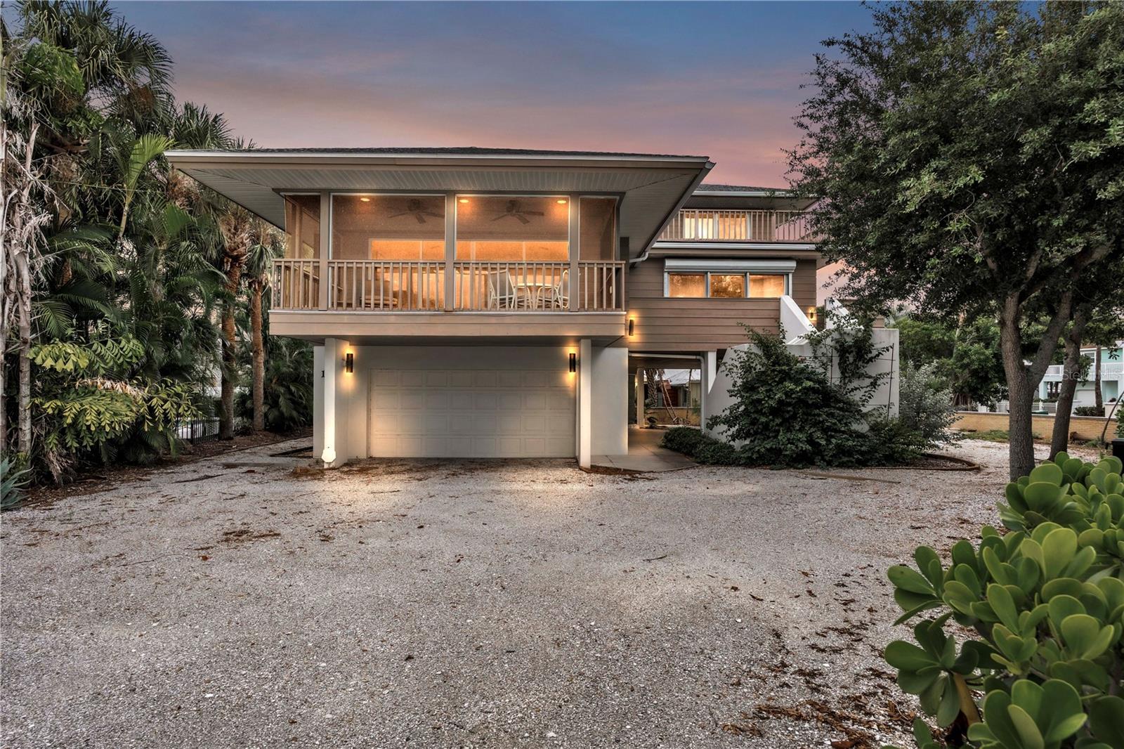 A premier setting defines this offering. Tucked at the end of a quiet cul-de-sac in Sunset Cove—a rare enclave that prohibits weekly rentals—this elevated beach residence presents an exceptional retreat for tranquil island living. Become part of a true neighborhood community, whether in full-time residence or seasonal escape, with breathtaking Gulf vistas just a stone’s throw from the sugar-white sands of Anna Maria Island and dedicated beach access moments away.
Designed by acclaimed architect H. Patterson Fletcher, this distinctive home embodies Frank Lloyd Wright–inspired principles, celebrating harmony with nature, fluid open spaces, and an abundance of natural light. Custom-built and solidly constructed, it occupies an expansive walled lot mere steps from the shoreline—offering the rare canvas to envision a private pool and bespoke outdoor sanctuary.
Spanning three thoughtfully appointed levels, the 3-bedroom, 2.5-bath residence with bonus room welcomes guests through a gracious foyer, with an oversized garage below providing exceptional storage. Within, vaulted ceilings and an expansive wall of sliding glass doors bathe the living room in soft, filtered light while framing serene views of swaying palms and shimmering Gulf waters. Off the living area sliders open to a generous elevated screened lanai—an inviting setting for languid afternoons, twilight gatherings, and al fresco dining.
The open-concept kitchen and living area flow together effortlessly, anchored by new appliances, a polished granite island, custom solid-wood cabinetry, and a double sized skylight that draws the sky inside. The primary suite offers a private balcony beyond its own wall of sliders, complemented by a spacious en suite bath and dual walk-in closets.
The upper level is a study in versatility—an adaptable retreat featuring two distinct sleeping areas and a full bath, accommodating visiting family and friends with comfort and privacy. When not hosting, the space transforms effortlessly into a den, library, home office, or creative studio. Wraparound windows and a rooftop deck reveal sweeping water and treetop panoramas—an ideal vantage for sunrise coffee, golden-hour cocktails, and starlit evenings.
While poised for cosmetic refinement, this residence's architectural provenance, enduring construction, generous grounds, and incomparable location make it an extraordinary canvas for a true luxury beach retreat.