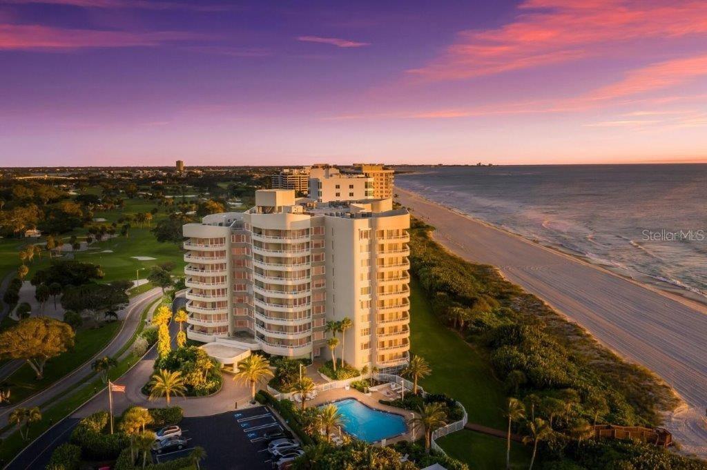Behind the gates of the Longboat Key Club, this exceptional residence at The Beaches captures sweeping, unobstructed views of the Gulf of Mexico and its pristine shoreline, where vivid sunsets paint the horizon each evening. Perched on the eighth floor, this coveted Star floor plan is ideally positioned as a spacious end residence, offering 2,122 square feet of thoughtfully designed living space with 3 bedrooms and 3 full baths. Walls of glass frame panoramic water vistas and invite natural light to pour into the main living areas. Newly installed impact-rated sliders enhance both storm protection and seamless indoor-outdoor living, while oak engineered hardwood flooring flows beautifully through the living room, dining area, and kitchen, creating a warm yet sophisticated coastal aesthetic. The generous layout provides an effortless blend of comfort and refinement, with well-proportioned bedrooms and baths designed to accommodate both everyday living and gracious entertaining. The Beaches is recognized as one of the premier beachfront addresses within the Longboat Key Club, offering direct access to the sugar-white sands and turquoise waters of the Gulf. Residents enjoy an elevated level of service and amenities, including a 24-hour concierge, resort-style pool, fitness center, tennis courts, and impeccably maintained grounds. Ideally located on the southern end of Longboat Key, this gated community affords convenient access to the fine dining and boutiques of St. Armands Circle, the vibrant arts and culture of downtown Sarasota, and the exclusive offerings of the Longboat Key Club. This is a rare opportunity to secure a front-row seat to the Gulf and embrace the effortless elegance of Florida’s most sought-after coastal lifestyle.