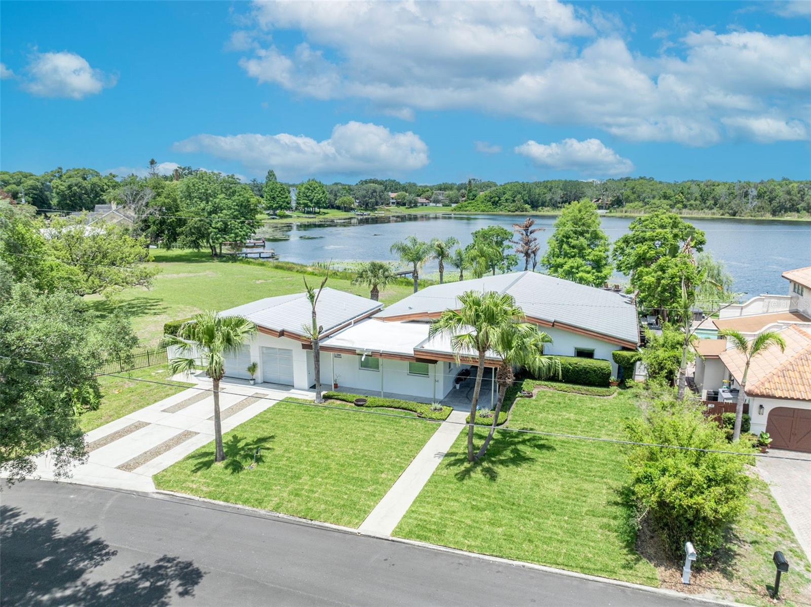 Winter Park lakefront home! A  rare opportunity to own a thoughtfully renovated mid century lakefront residence in Winter Park. This three bedroom four bath home offers stunning views, high ceilings and abundant natural light.  The open layout flows effortlessly for everyday living and gatherings with friends and family.  As you walk through the front door, you will be drawn to the large living area and a wall of windows and doors leading to the lake. The island kitchen is a cook's dream with abundant workspace and welcoming island seating. Imagine waking up every morning to yet another amazing view- The primary suite is  spacious and private with newer bath and large walk- in closet. Nicely appointed secondary bedrooms and updated baths. In addition to the main living area, there is a separate oversized family room with a full bath adjacent. This home is a perfect blend of classic architecture and carefully designed updates.  Other features include two car garage with "glass" overhead doors and  mini-split HVAC, metal roof, generous closets & storage throughout and recently installed sod. What makes this house truly special is the setting on Lake Spier- a ski lake tucked away in a secluded part of Old Winter Park . There are no homes across the lake- so spending time on the patio and  dock offers an expansive view of water and trees and a remarkable sense of privacy. Inside and out, every space feels connected to the natural beauty. Great location to enjoy Winter Park living. Ideally situated near top rated schools - Baldwin Park, Glenridge and Winter Park High School. Enjoy close proximity to walking trails, restaurants and shopping. This home is truly special!
