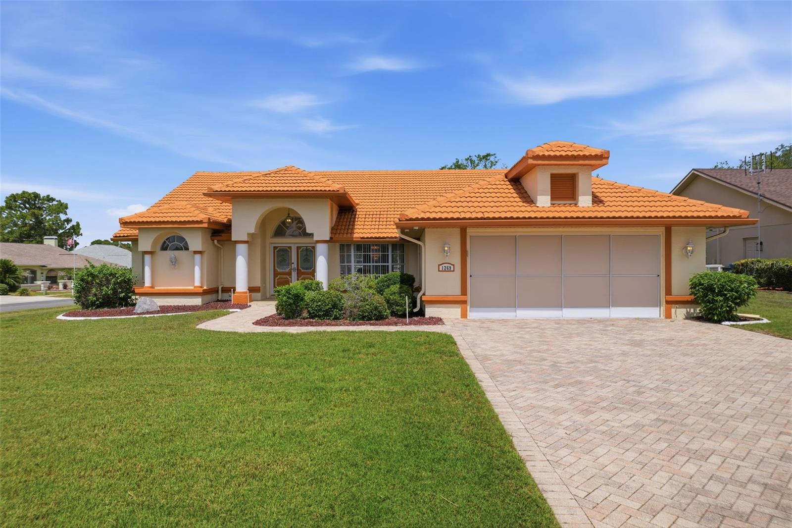 Virtually Staged. Set on an oversized cul-de-sac lot in the Seven Hills community, this beautifully maintained pool home showcases the Florida lifestyle at its finest. Offered partially furnished, this exceptional property is ready to be enjoyed from the moment you move in. A sprawling screened pool with a paver deck, an oversized covered lanai complete with a wet bar, and extensive May 2026 updates- including luxury vinyl plank flooring, new quartz countertops in both bathrooms, and a beautifully renovated primary bath - create a home that is both stylish and move-in ready. The paver driveway and decorative glass front doors protected by full-view storm doors provide an elegant welcome. Step inside the grand foyer, where soaring ceilings and new luxury vinyl plank flooring set the tone for the spacious interior. A convenient coat closet is tucked just inside the entry. The living room features cathedral ceilings, brand-new dual ceiling fans, and a wall of sliding glass doors topped with transom windows that draw your attention to the outdoor living space beyond. Adjacent to the living room, the formal dining room offers a beautiful setting for entertaining, highlighted by a bay window and an upscale chandelier. The kitchen is stylish with solid wood cabinetry, granite countertops, a breakfast bar, double sink, and matching luxury vinyl plank flooring. The adjoining breakfast nook is surrounded by large windows and sliding glass doors, creating a bright and inviting space to enjoy meals while overlooking the lanai and pool area. A built-in serving bar with matching granite countertops, solid wood cabinetry, and a mini refrigerator adds convenience for entertaining. Above the bar, a built-in whole-home speaker system allows music to be enjoyed throughout the home. The primary suite offers direct access to the pool and lanai through sliding glass doors, a walk-in closet, well-maintained carpeting, and a versatile alcove ideal for a home office, reading nook, or exercise space. The beautifully renovated en-suite bathroom, features luxury vinyl plank flooring, dual vanities with abundant counter space, Carrara quartz countertops, a soaking tub beneath a transom window, and a separate walk-in shower, all finished in a bright, clean, timeless design. Two additional bedrooms feature large windows, built-in closets, and well-maintained carpeting. The nearby guest bathroom serves as an ideal pool bath with direct access to the lanai. Updates include luxury vinyl plank flooring, a Carrara quartz vanity, updated gold fixtures, a framed mirror, and features a tub/shower combination with a frosted window. The true centerpiece of this home is the outdoor living area. The expansive covered lanai provides room for relaxing or entertaining and includes a wet bar. A retractable accordion-style storm wall offers additional protection during severe weather. Beyond the lanai, the screened pool includes an attached automatic pool vacuum system. Blooming crape myrtles and landscape curbing adds a polished finishing touch to the outdoor spaces. Additional features include an interior laundry room with washer and dryer included, extensive overhead cabinetry, and a utility sink. The two-car garage offers checkerboard flooring, screened sliding garage doors, a split A/C unit, automatic garage door opener, additional storage space, a storage cabinet, and direct access to the side yard. The home is also pre-wired for a security system and already equipped with cameras.