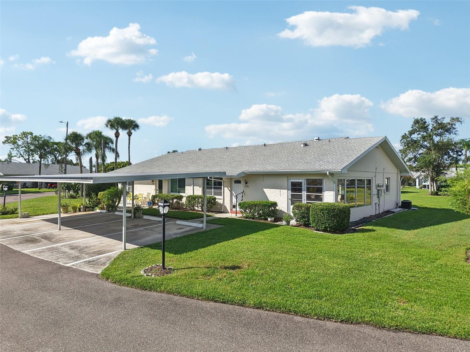 Welcome to the highly sought-after, golf cart-friendly 55+ gated community of Kings Point! This desirable end-unit condo located on a peaceful roundabout with courtyards views. *** Enjoy true maintenance-free living with condo fees that include cable, water, sewer, trash, pest control, lawn care, roof repair/replacement, and access to an incredible array of resort-style amenities. Residents enjoy over 200 clubs and activities, multiple indoor and outdoor heated pools, fitness centers, pickleball, on-site salons, two restaurants, and so much more — all without ever needing to leave the community! *** A covered carport is located just steps from the front door. *** The popular Glenmore floor plan is a well maintained home offering 2 bedrooms, 2 bathrooms, and a bright Florida Room perfect for relaxing and enjoying the views. The spacious living and dining areas create an open layout ideal for both everyday living and entertaining. *** The kitchen features abundant cabinetry, generous counter space, and a dishwasher for added convenience. The dishwasher, microwave, washer and dryer are brand new and never been used. The large primary suite easily accommodates king-size furnishings and includes a full wall of closets along with a private en-suite bath. With a large interior laundry room, water softener system, with storage and everyday functionality. *** Association allows 30-day minimum rentals, offering excellent flexibility for seasonal or investment opportunities. Residents of Kings Point enjoy access to two clubhouses featuring resort-style amenities, including lap pools, aerobic pools, expansive gathering decks, cookout spaces, social events, and endless opportunities to stay active and connected. ***Some photos are AI to show the possibilities of tranquil retirement home.