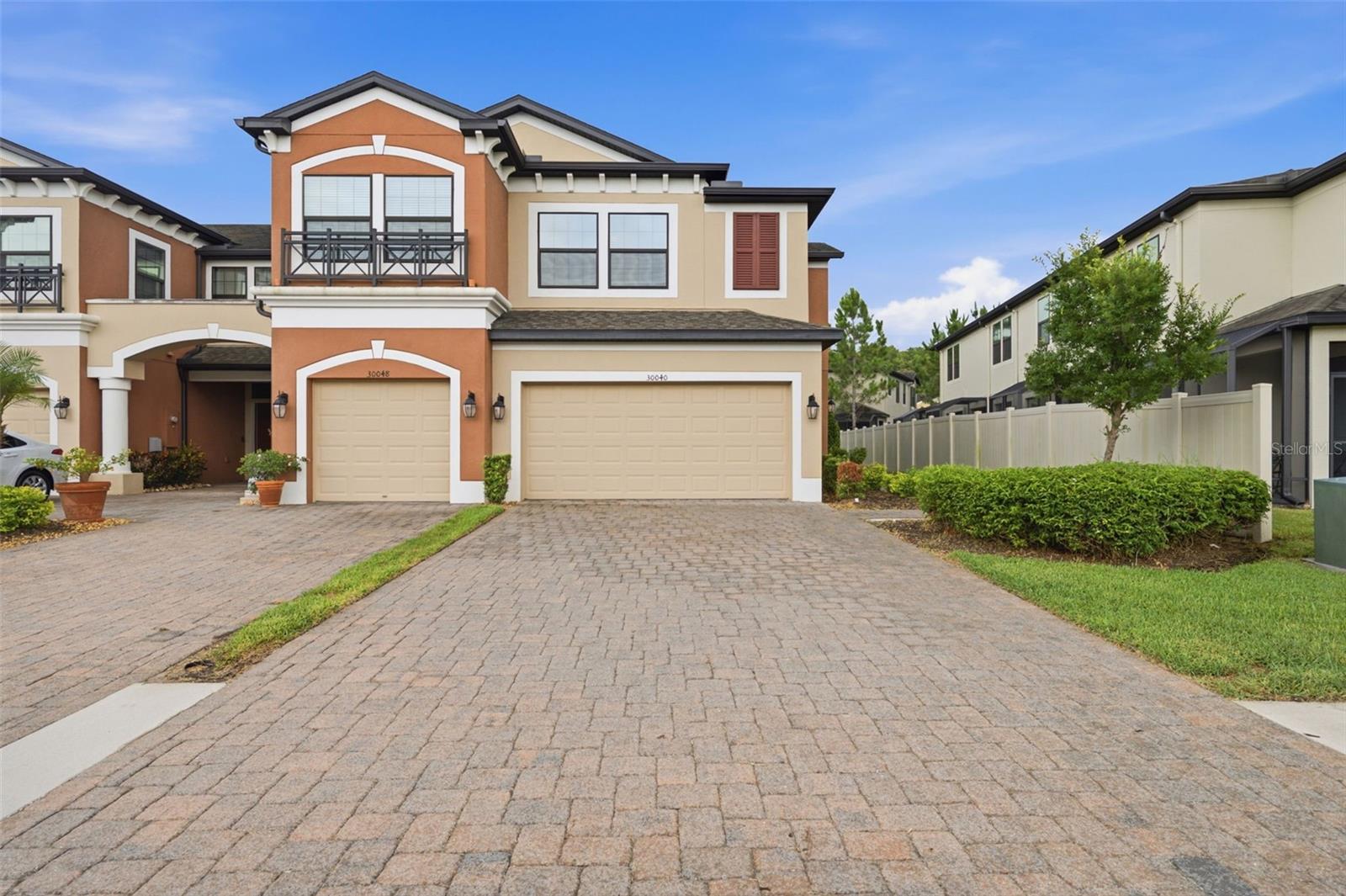 Welcome to Windermere Estates, a highly sought after gated community in the heart of Wesley Chapel. This move in ready end unit townhome offers 3 bedrooms, 2.5 bathrooms, a spacious loft, 2,153 square feet of living space, a 2 car garage with automatic opener and remotes, paved driveway, and private walkway entry. Built in 2019 and meticulously maintained, recent updates include brand new carpet and fresh interior paint throughout the home and garage. Plank tile flooring spans the entire first floor, complementing an open design that seamlessly connects the kitchen, dining, and living areas. The kitchen features quartz countertops, stainless steel appliances, 42 inch cabinetry with crown molding, a spacious walk in pantry, large center island, built in microwave, dishwasher, and an eat in dining area. A convenient half bath and laundry room with washer and dryer included complete the first floor. Upstairs, all bedrooms are thoughtfully positioned for privacy. An impressive loft measuring approximately 23' x 12' offers endless possibilities as a media room, game room, home office, fitness space, or second family room. The primary suite (20X14) features a large walk in closet and a beautifully appointed bath with dual vanities, dedicated seated vanity area, and oversized walk in shower. Both guest bedrooms feature walk-in closets, providing generous storage space and added convenience. The secondary bath is equally functional with dual vanities and a full bathtub. Enjoy added privacy and natural light afforded by the end unit location, along with a screened lanai perfect for morning coffee or evening relaxation. Residents enjoy resort style amenities including a sparkling pool, cabana, poolside restrooms, scenic walking paths, tranquil pond views, and an observation deck overlooking the water, creating the perfect setting to relax and enjoy Florida living. HOA services provide exceptional value and include roof repair and replacement, exterior building maintenance, exterior painting, landscaping, irrigation, pest control, water, sewer, trash, gated entry, and common area maintenance. Pet friendly and investor friendly, Windermere Estates allows rentals with a minimum one year lease. Ideally located near I 75, Wiregrass Mall, Tampa Premium Outlets, AdventHealth, BayCare Hospital, dining, entertainment, and top rated schools. Combining location, lifestyle, and low maintenance living, this turnkey home is ready for its next owner. HVAC system has been professionally serviced every six months since purchase, reflecting consistent preventative maintenance and care. Buy a Little Piece of Florida Now. Property video available upon request.