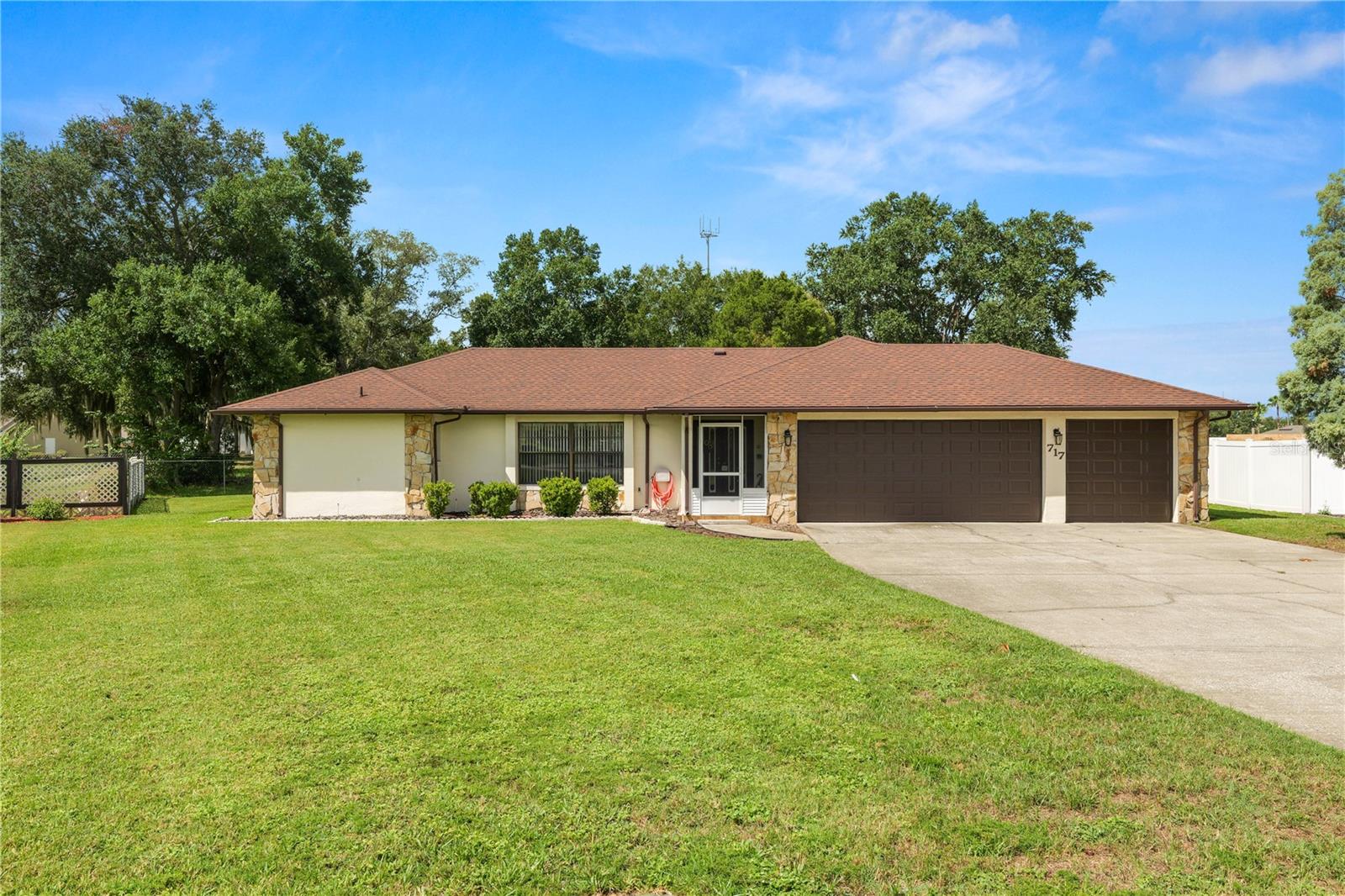 Enjoy the freedom of NO HOA living in this beautifully maintained North Lakeland home, ideally situated on a spacious lot in a USDA-eligible area! Blending timeless Florida ranch charm with thoughtful modern updates, this inviting residence offers a spacious split-bedroom floor plan, multiple living and dining areas, and a warm, welcoming atmosphere that's perfect for both everyday living and entertaining. At the heart of the home, the family room features a striking floor-to-ceiling stone electric fireplace, creating a cozy focal point for gathering with family and friends. The well-appointed kitchen offers abundant cabinetry, generous counter space, a breakfast bar, and a casual dining area overlooking the backyard. Complete with a suite of The refrigerator was new in 2020 and all other kitchen appliances are five years old or newer, it's designed to make everyday living and entertaining effortless. The private primary suite provides a relaxing retreat, while the additional bedrooms offer flexibility for family, guests, or a home office. An enclosed Florida room extends the living space and provides the perfect setting to enjoy your morning coffee, unwind after a long day, or take in views of the expansive backyard. Car enthusiasts, hobbyists, or anyone needing extra storage will appreciate the oversized three-car garage, offering ample space for vehicles, tools, recreational equipment, or a workshop area. Designed with peace of mind in mind, this home has been extensively updated, including a new septic system (2025), roof (2021), HVAC system (2021), water heater (2022), garage doors (2021), irrigation system (2021), and an updated electrical panel.  The AC has a warranty and is transferable. Additional improvements include luxury vinyl plank flooring, updated bathroom flooring, modern lighting, new ceiling fans, refreshed bathrooms, and updated door hardware throughout, making this home truly move-in ready. Conveniently located just minutes from shopping, dining, medical facilities, and the Polk Parkway, you'll enjoy the perfect balance of peaceful surroundings and everyday convenience. With its generous lot, desirable location, timeless character, oversized three-car garage, and extensive updates already completed, this move-in-ready home is ready to welcome its next owners.