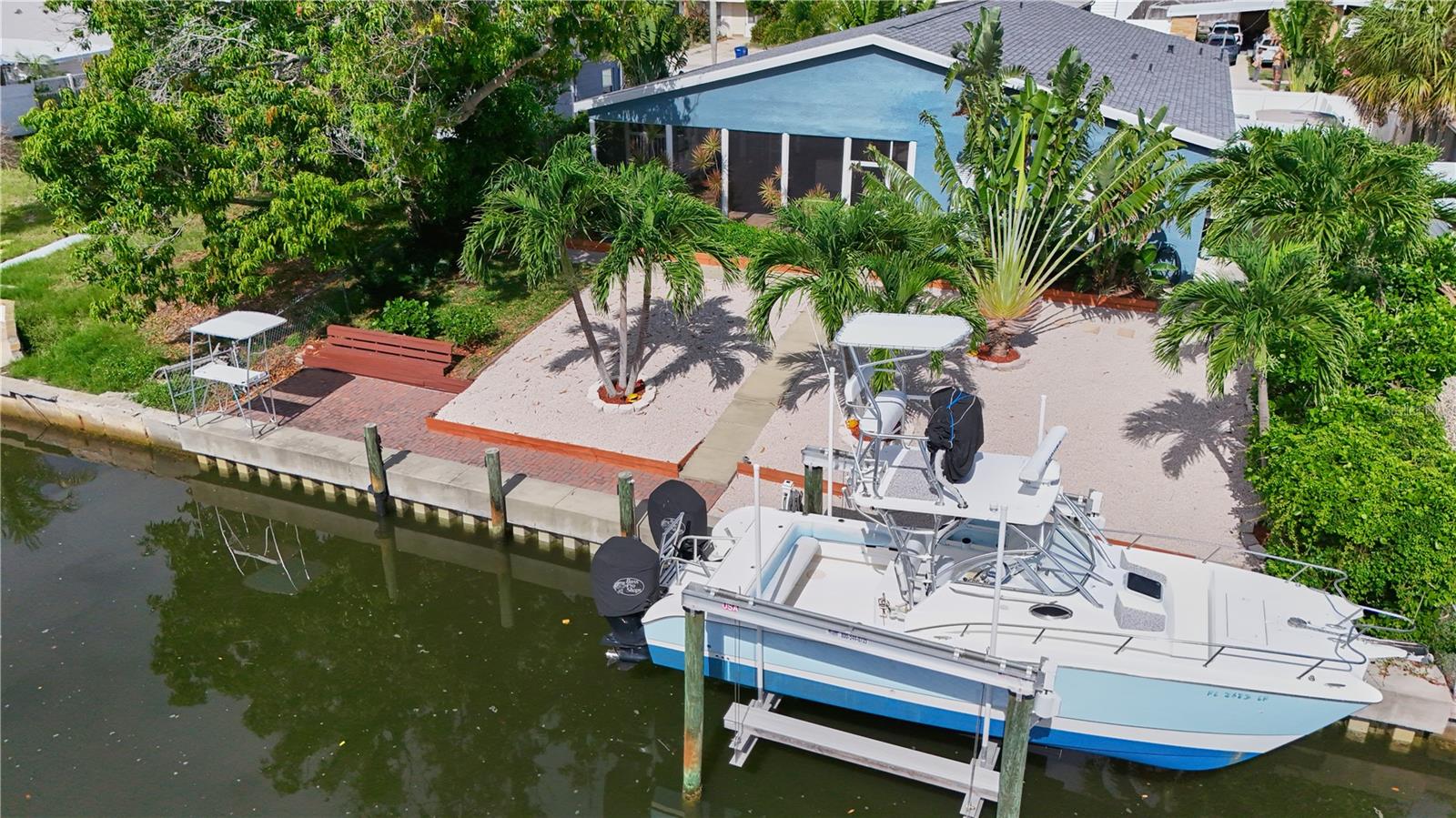 INCREDIBLE, NEW PRICE!!! This tropical adventure home is the one you've been waiting for, where everyday living is a waterfront vacation!! This fully updated 2,400 sq ft, 4 bedroom/3 full bath home, is nestled on a deep, sailboat water canal with direct access to Sarasota Bay and the Gulf of America (no bridges) -  a boater’s paradise with wide, unobstructed access to sandbars, deep-water fishing, water sports, waterfront restaurants, beaches and more - all within minutes!! Enjoy 70 FEET of water frontage on this canal (with extra-wide width)!  In 2020, a NEW DOCK, NEW 16,000 lb. BOAT LIFT!! NEW SEAWALL (2015), and a fish cleaning station was completed!! You'll experience peace of mind here with a NEW ROOF!! NEW A/C (1 unit), 2-A/Cs. for zoned efficiency, impact-resistant windows, 2-Newer hot water heaters, newer appliances throughout! There is WHOLE-HOME GAS ENERGY for huge savings (also has full electric for flexible options). This home was never affected by Hurricanes nor storm surges! Entering the home, you'll be greeted with with an OPEN FLOOR PLAN, NEW TILE THROUGHOUT, NEW large, CUSTOM KITCHEN with REAL WOOD CABINETS and generous, STONE COUNTERTOPS and bar seating! The dining/flex space is currently enjoyed as a game room with a pool table perfectly situated for family and friends to have fun. There are TWO generously-sized PRIMARY bedrooms (en suites) with updated bathrooms offering many flexible options for guests or mother-in-law suite possibilities. There is a spacious, indoor laundry room. Don't miss all the hall closets that were smartly added during 2003 renovations.  Step into the heartbeat of this exceptional home - the EXPANSIVE, UNDER ROOF/SCREENED LANAI! This sanctuary offers year-round enjoyment of endless sunsets overlooking the canal and is embraced by the tropical retreat of the upgraded grounds and rich, tropical landscaping.  Whether your entertaining large gatherings with Al fresco dining or taking a rest after boating/fishing with family, this large space is set-up for it all with brand new tile flooring, large outdoor kitchen/bar, gas stove cooking (perfect for your fish), refrigerator, deep freezers (perfect for your fresh catch of grouper), and a commercial ice maker! There is ample space for a future pool. Bring your RV - there is dedicated parking on the side of home with vinyl gate/fencing. You'll appreciate additional parking spaces which includes a carport, extended and circular driveway. The yards have well-irrigation throughout (more savings). There are NO HOA/NO DEED RESTRICTIONS - (NO FEES), but residents of Bayshore Gardens enjoy an amenity-rich community with an Olympic-sized pool (only $10/year key fob access), pickleball, tennis, basketball courts, playgrounds, a wood shop, private marina, and boat launch.  This home is located in a coveted location with convenient access to award-winning beaches, Anna Maria Island, Siesta Key, SRQ Airport, IMG Academy, Downtown Sarasota dining and shopping. Homes like this at this price point, with direct Gulf access and waterfront/canal living, do not last long, so schedule your private showing today and let your ultimate, Florida waterfront lifestyle begin! Be it a full-time home, vacation retreat, or an income-producing rental (short term rental IS allowed), you'll quickly see the unrivaled value this home has to provides for waterfront living in Bradenton/Sarasota! Pool table, 2 deep freezers, commercial ice maker, remain! Furnishings are negotiable!