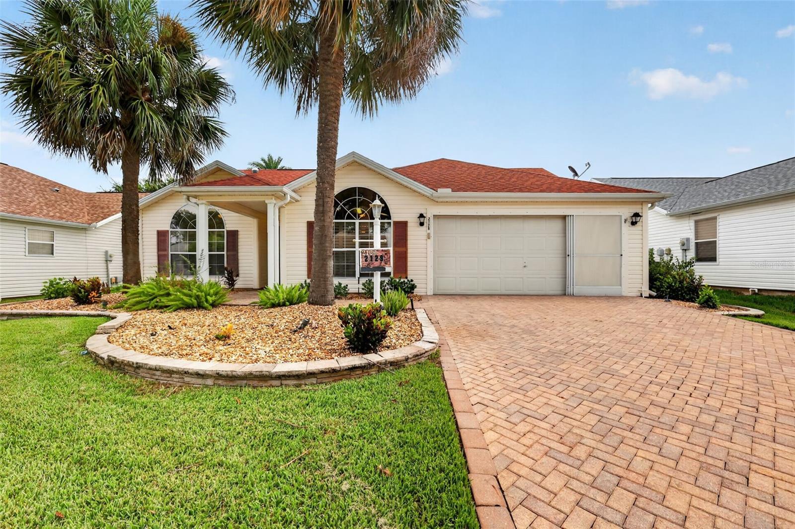 NO BOND! Beautifully Maintained, One Owner, Designer Home in the Village of Santo Domingo.

Discover effortless sophistication in this home that is  perfectly positioned between Spanish Springs Town Square and Lake Sumter Landing. Offering convenient access to shopping, dining, entertainment, golf, and all the amenities that define The Villages lifestyle. A new roof installed in 2020 provides added peace of mind.

Mature landscaping, a paver driveway, and decorative landscape curbing create inviting curb appeal as you arrive. Inside, vaulted ceilings, luxury vinyl plank flooring, and solar tube skylights fill the home with natural light, enhancing the bright and welcoming atmosphere.

The kitchen features abundant cabinet storage, a spacious eat-in nook framed by a large window, and a pass-through opening to the living room, maintaining an open feel while still offering defined living spaces.

Just off the living room, a versatile flex room provides the perfect space for a home office, den, hobby room, or additional seating area. This room offers access to both a charming pergola and a tranquil screened porch, giving you two inviting outdoor living areas to enjoy.

The split floor plan enhances privacy for you and your guests. The generous primary suite includes two walk-in closets, one in the bedroom and another in the bathroom, along with a walk-in shower. The guest bathroom features a tub/shower combination for added convenience.

A two car garage and included washer and dryer add even more convenience to this move in ready home.

Experience refined living in one of The Villages most desirable locations. Schedule your private showing today!
