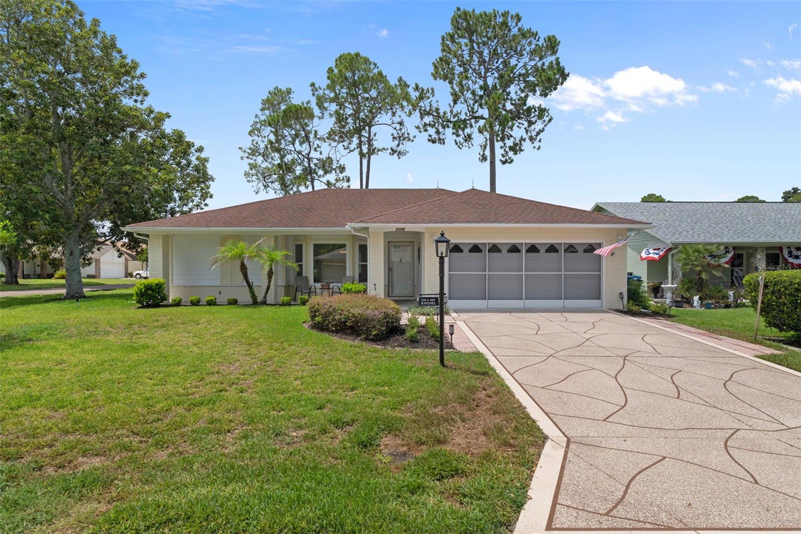 Welcome home to one of the most desirable addresses in the award-winning, guard-gated golf community of Timber Pines. Perfectly positioned on a beautifully landscaped corner lot, this stunning, move-in ready residence combines timeless curb appeal with thoughtful modern updates, creating a home that is as inviting as it is impressive. From the moment you arrive, you'll notice the exceptional pride of ownership. A resurfaced stamped driveway (2026), manicured landscaping, screened two-car garage, and an expansive 29-foot covered front porch create the perfect setting to enjoy Florida's beautiful weather while welcoming family, friends, and neighbors. Step inside through the decorative glass storm door to discover an open, light-filled floor plan where nearly every detail has been refreshed. Luxury vinyl plank flooring flows throughout the main living areas while an integrated stereo speaker system provides the perfect soundtrack for everyday living and entertaining. The completely redesigned kitchen is truly the heart of the home, offering granite countertops, stainless steel appliances, a deep single-basin sink, custom tile backsplash, recessed LED lighting, crown molding, pantry, breakfast bar, and a dedicated prep area that easily serves as a coffee station or entertaining bar. Just beyond, the oversized laundry room provides exceptional storage with abundant cabinetry, a utility sink, and generous workspace. The spacious family room impresses with soaring cathedral ceilings, a transom window, chair rail detailing, and seamless flow into the spectacular 25-foot vinyl-enclosed Florida room. Featuring dual ceiling fans and updated blinds, this versatile space becomes a year-round extension of the home--perfect for morning coffee, afternoon reading, or hosting guests. Step outside to your private rear yard, ideal for grilling or enjoying peaceful evenings under the Florida sky. Designed with privacy in mind, the split-bedroom floor plan offers comfortable accommodations for both homeowners and guests. The oversized primary suite serves as a relaxing retreat with two walk-in closets, private access to the Florida room through French doors, and a beautifully remodeled spa-inspired ensuite featuring dual vanities and a tiled walk-in shower. Pocket doors create an added sense of privacy, while the guest suite occupies its own wing with an updated bathroom complete with a tiled tub/shower combination and custom bench. Both bathrooms showcase beautiful stained-glass windows that add warmth and character. Additional upgrades include a newer water heater, updated blinds, gutters, outdoor lighting, lightning rod protection, a private mailbox, and an exceptional screened garage featuring epoxy flooring, built-in cabinetry, abundant storage, a side service door, and garage door opener. Life in Timber Pines is about far more than just a beautiful home. This vibrant, gated golf course community offers an unmatched lifestyle with championship golf, multiple clubhouses, pools, pickleball and tennis courts, fitness facilities, countless social clubs, and activities designed to help you enjoy every day to its fullest. If you've been searching for a beautifully updated home where every improvement has already been completed and all that's left to do is move in and start enjoying the Timber Pines lifestyle, this exceptional property is ready to welcome you home.