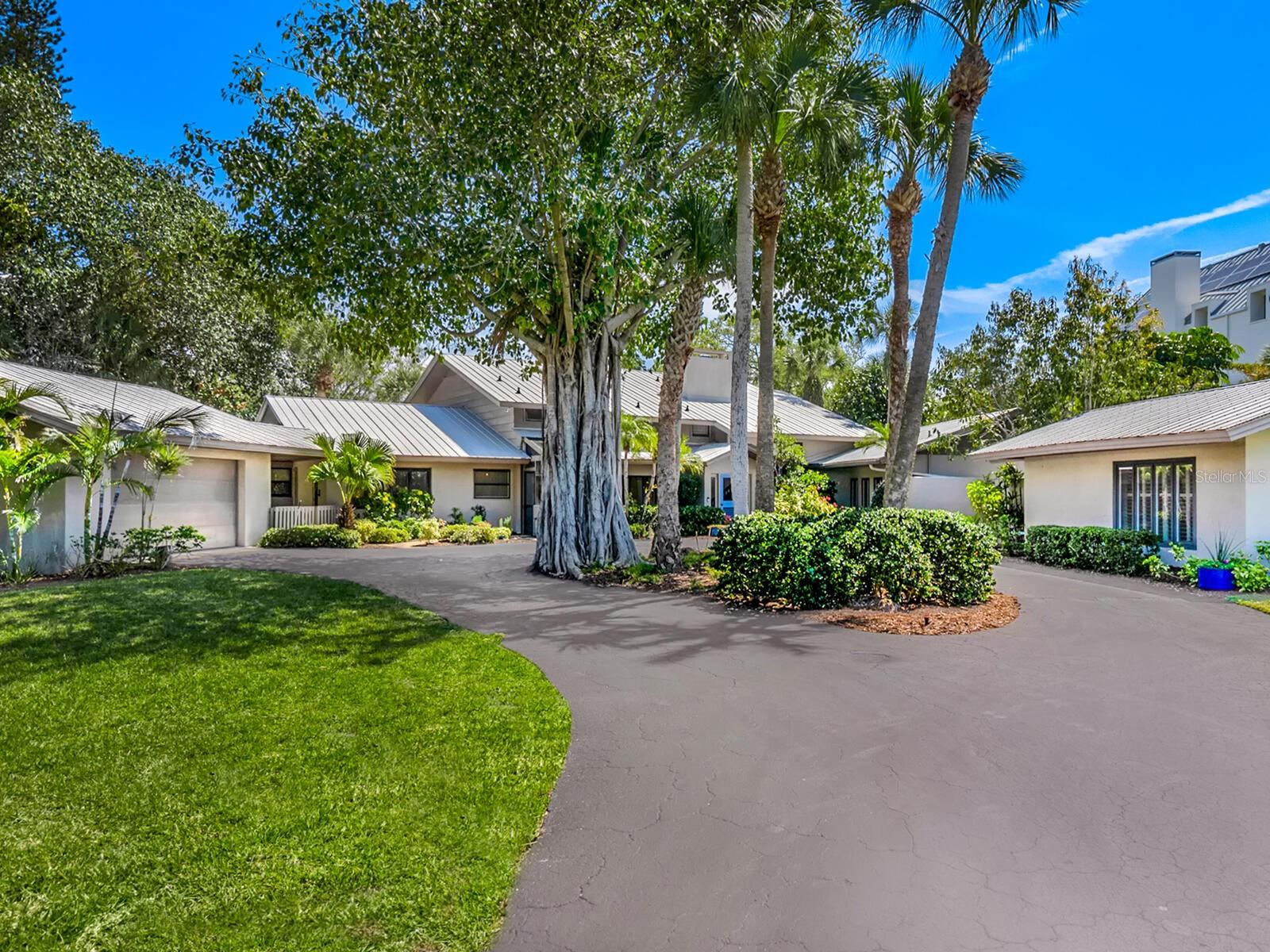 Welcome to your exclusive island retreat at 7435 Sanderling Road, where luxury and coastal charm merge seamlessly to create the ultimate beach living experience. Nestled behind the gates of the esteemed Sanderling Club, this spacious estate offers a sanctuary of tranquility on the shores of enchanting Heron Lagoon. As you arrive, be greeted by meticulously landscaped grounds, setting the stage for the treasure that lies beyond. Spanning over ¾ acre, this property boasts 4,638 sq. ft. of combined living space, comprised of a captivating two-story main home and a charming guest house. Designed to embrace the essence of island living, this residence welcomes families and guests alike, with ample room for leisure, relaxation, and entertainment. Step into the spacious living room, where a large picture windows frames panoramic views of the lush surroundings. Adjacent, the sunlit dining room invites you to savor every meal amidst the splendor of nature, courtesy of sliding glass doors that seamlessly merge indoor and outdoor living. Upstairs, the primary suite awaits, offering a serene sanctuary complete with a sitting area adorned with vaulted ceilings and breathtaking vistas. Step out onto the second-story wooden deck within the screened lanai, where the sights and sounds of coastal bliss await. Indulge in the luxury of dual primary baths, featuring a rejuvenating jacuzzi tub, expansive vanity, and a step-in shower, while four guest bedrooms ensure comfort for loved ones. The welcoming guest house suite provides a private oasis for discerning visitors. Outside, the allure of the lagoon beckons, with a private dock for swimming and kayaking; and a walkway leads to the pristine shores of Crescent Beach. Experience the epitome of relaxation amidst lush greenery and vibrant sunsets, where fishing, canoeing, paddleboarding and kayaking await at your doorstep. Beyond the confines of this exquisite estate, indulge in island living at its finest. With unrivaled privacy, the Sanderling Club on Siesta Key's coveted Gulf of Mexico coast offers unique architecture on meandering lanes in an Old Florida setting. Community members enjoy activities and social events in a clubhouse designed by famed architect Paul Rudolph, with a large waterfront patio and grilling area with Gulf swimming access, private tennis, pickleball and volleyball courts, and a playground. Enjoy breathtaking views of the Gulf all day from the historic beach cabanas and clubhouse, and savor blazing sunsets each night. A boater’s delight, the community also offers a private bayfront marina with direct sailboat access to Sarasota Bay, Intracoastal Waterway, and the Gulf of Mexico. Only minutes to Siesta Key’s crystal quartz sands and Siesta Village for shopping and restaurants. Culturally rich downtown Sarasota restaurants, theater, ballet, opera, museums, galleries, and shopping are a short drive away.