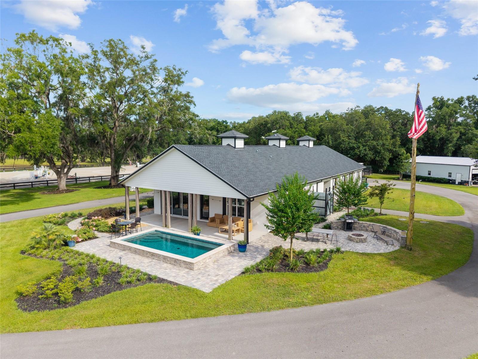 Discover the pinnacle of equestrian luxury on this stunning 36-acre horse farm in Morrison, Florida. Built in 2022-2023, this turnkey property offers brand-new construction throughout, featuring an exceptional six-stall barn complete with a spacious two-bedroom, two-bathroom apartment that rivals a private residence. Enjoy resort-style living with a private pool, full-property generator backup for uninterrupted comfort, and immaculate landscaping that sets the stage for effortless country elegance. A beautiful pond with fountain, fire pit, and  6 run in sheds with stalls in the paddocks complete this serene retreat. Equestrian enthusiasts will appreciate the premier facilities, including a full-drain-base irrigated GGT jumping arena and thoughtfully designed paddocks. A separate storage barn provides ample space for farm equipment and fuel tanks. Perfectly located in the heart of Marion County’s horse country, this one-of-a-kind property blends modern sophistication with functional farm living—ideal for the discerning buyer seeking excellence in every detail.