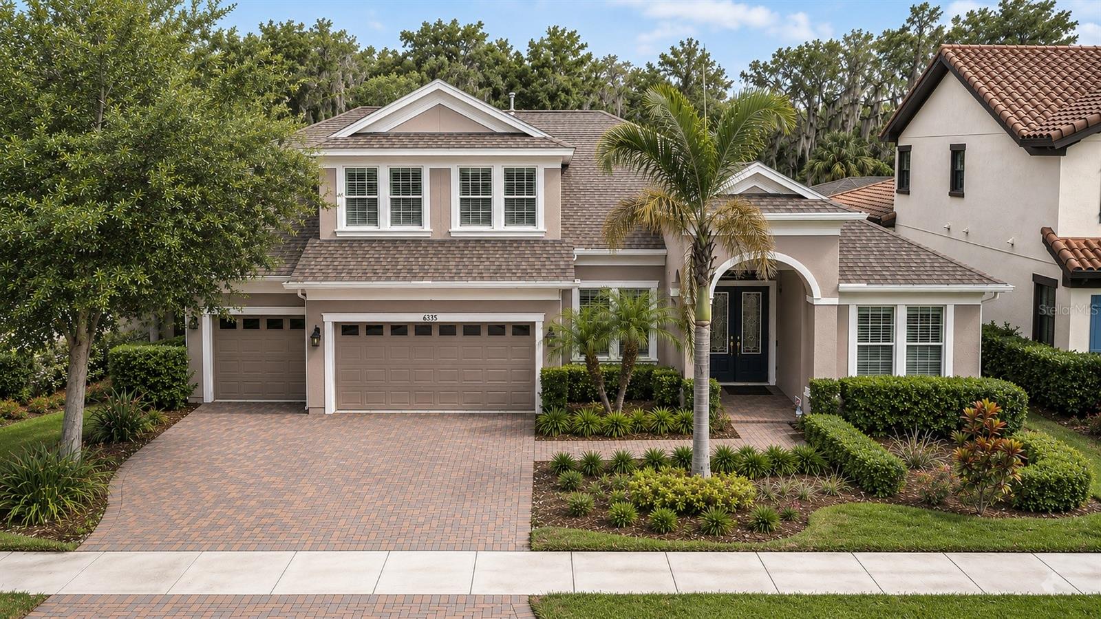 The moment you walk through the front doors of this stunning Key Largo II by WestBay, you'll understand why this floor plan remains one of the most sought-after designs in FishHawk Ranch West. Soaring 14-foot ceilings stretch across the main living areas, creating an immediate sense of grandeur and openness that carries throughout the home’s 3,560 square feet of thoughtfully designed living space. Designed with both everyday comfort and effortless entertaining in mind, this exceptional residence offers 5 bedrooms, 4 full bathrooms, a 3-car garage, and an open-concept layout that lives beautifully. The heart of the home is an expansive gathering space where the kitchen, dining area, and great room seamlessly connect beneath the impressive ceiling heights, creating a bright and welcoming atmosphere. The chef's kitchen is perfectly positioned for entertaining and features a massive island with extended seating, built-in appliances, abundant cabinetry, a walk-in pantry, and plenty of workspace for preparing everything from weeknight dinners to holiday feasts. Just beyond, the spacious living area offers an inviting setting for gathering with family and friends while maintaining the home's seamless flow and contemporary design. One of the most desirable aspects of the Key Largo II is its versatile floor plan. Four bedrooms, including the luxurious primary suite, are conveniently located on the first floor, providing exceptional functionality for families and guests alike. The primary retreat offers a peaceful escape with a spa-inspired bath, dual vanities, a soaking tub, separate shower, and two generous walk-in closets, providing abundant storage and organization. Upstairs, you'll find the perfect private retreat featuring an oversized bonus room, a fifth bedroom, and a full bathroom. Whether used as a guest suite, media room, game room, or multi-generational living space, this flexible area offers endless possibilities while maintaining privacy from the rest of the home. Step outside and discover what truly sets this property apart. The screened lanai and sparkling saltwater pool with a premium PebbleTec finish overlook a tranquil conservation backdrop, where mature oak trees create a picturesque setting and a sense of serenity that's increasingly hard to find. From morning coffee to evening sunsets, the peaceful views provide the perfect extension of Florida living. Additional valuable upgrades include a water softener system and an energy-efficient electric tankless water heater, enhancing both comfort and efficiency. Situated within The Oaks at FishHawk Ranch West, residents enjoy access to premier community amenities including resort-style pools, fitness facilities, dog parks, playgrounds, and the Lake House overlooking beautiful Lake Hutto. Combined with top-rated schools and a prime location, this home offers the perfect balance of luxury, lifestyle, and natural beauty. Rarely does a home combine an award-winning floor plan, breathtaking ceiling heights, flexible living spaces, exceptional upgrades, and peaceful conservation views so effortlessly. This is more than a home—it's a lifestyle.
