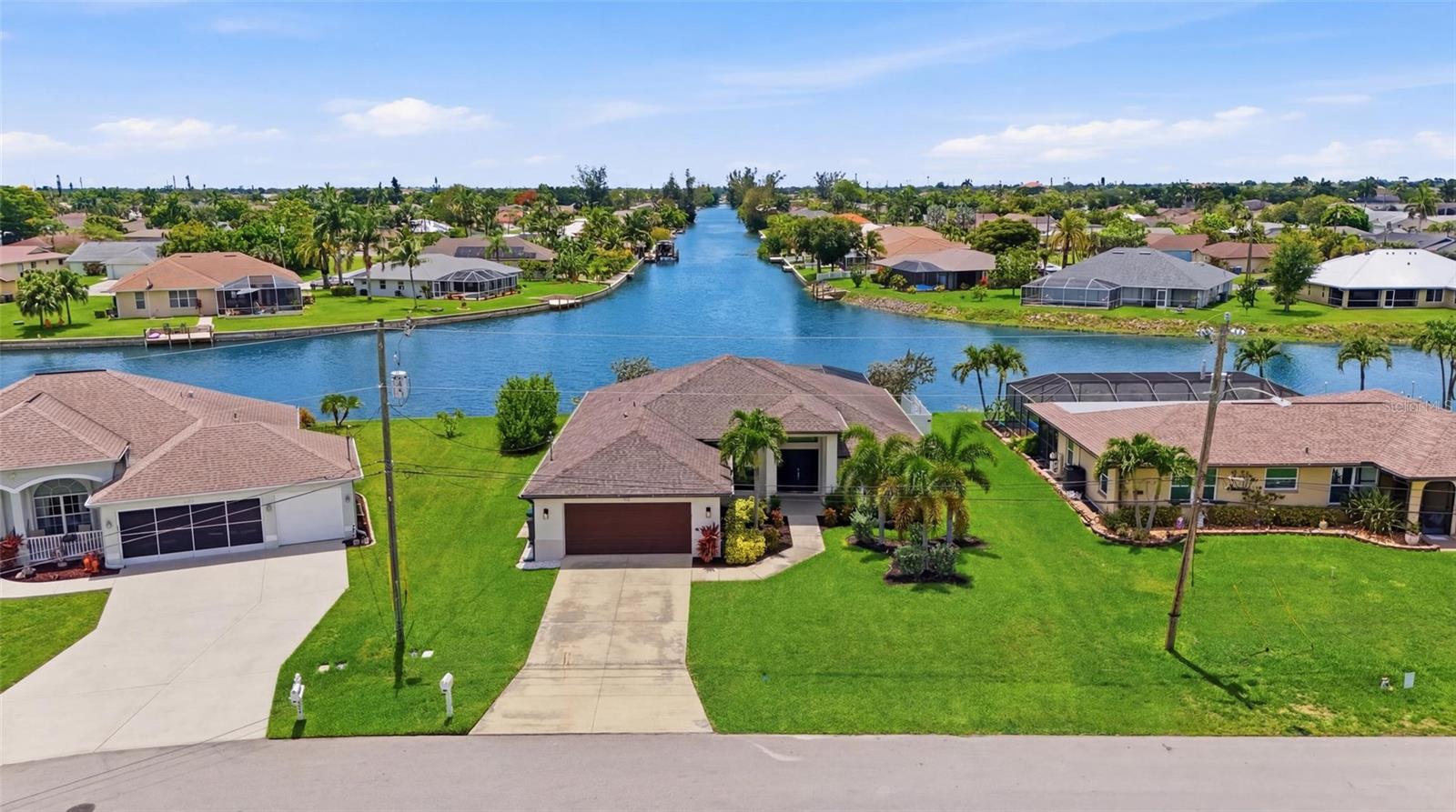 Wake up to sparkling intersecting canal views, spend your afternoons lounging beside your heated pool, and end every evening with breathtaking Southwest Florida sunsets—all from this exceptional turnkey waterfront retreat that sits safely outside of a flood zone and offers proven vacation rental income potential.

Perfectly positioned on a premium oversized waterfront homesite, this beautifully maintained 4-bedroom, 2-bathroom villa offers nearly 2,000 square feet of thoughtfully designed living space and is being sold fully furnished with stylish coastal décor, allowing you to begin enjoying the Florida lifestyle—or generating rental income—from day one.

From the moment you arrive, the home's impressive curb appeal, tropical landscaping, and welcoming entry create an immediate sense of arrival. Inside, soaring ceilings and an expansive open-concept floor plan seamlessly connect the living room, dining area, and gourmet kitchen, all thoughtfully designed to maximize natural light and showcase the stunning water views beyond. The spacious kitchen features rich wood cabinetry, granite countertops, stainless steel appliances, abundant storage, and an oversized breakfast bar that comfortably accommodates family and guests alike.

The primary suite serves as a private waterfront sanctuary, complete with direct pool access, tranquil water views, oversized walk-in closets, dual vanities, a soaking tub, and a large walk-in shower. Guest bedrooms are generously sized and thoughtfully positioned to provide privacy and comfort for family and visitors.

The true centerpiece of the home is the spectacular outdoor living area. A recently installed pool cage frames panoramic intersecting canal views while creating the perfect environment for year-round enjoyment. The heated pool, expansive paver lanai, covered outdoor dining area, and western rear exposure combine to create an entertainer's dream and a front-row seat to some of Cape Coral's most spectacular sunsets. Whether hosting guests, enjoying a quiet morning coffee, or relaxing poolside after a day on the water, this outdoor oasis embodies the best of Florida living.

For investors, this property presents an outstanding opportunity as a successful and established vacation rental with strong appeal to seasonal visitors seeking turnkey waterfront accommodations. For homeowners, it offers the rare combination of move-in-ready convenience, breathtaking water views, modern updates, and peace of mind with its non-flood-zone location.

Located close to shopping, dining, golf courses, parks, boating, and all the conveniences that make Cape Coral one of Southwest Florida's most desirable destinations, 206 NE 21st Avenue delivers an exceptional blend of lifestyle, luxury, investment potential, and waterfront living.

Turnkey, updated, and ready to enjoy—this is the waterfront pool home buyers and investors have been waiting for.