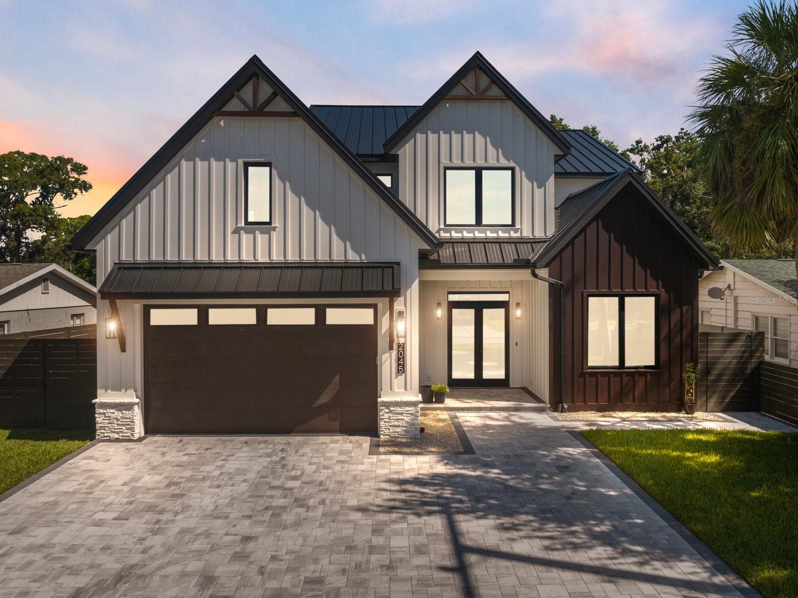 One or more photo(s) has been virtually staged. Experience elevated coastal living in this nearly new Coastal Modern Farmhouse, thoughtfully built in 2025 by WG Homes with exceptional quality and craftsmanship. Constructed with solid block all the way up and topped with a standing-seam metal roof, this two-story residence offers five bedrooms, four-and-a-half baths, and a spacious, well-designed layout ideal for both everyday living and entertaining.
Inside, soaring ceilings and abundant natural light define the open first-floor living spaces, complemented by beautiful wood flooring and designer finishes throughout. The chef’s kitchen features top-of-the-line Thermador appliances, a large hidden walk-in pantry, dry bar, and seamless flow to the dining and living areas. A private office, along with a well-appointed laundry and mudroom, enhances everyday functionality. The first-floor primary suite offers a serene retreat with a soaking tub, spa-inspired shower, and expansive walk-in closet designed for comfort and convenience.
Upstairs, you’ll find three bedrooms, three full bathrooms, and a spacious bonus room with closet that could easily function as an additional bedroom, media room, playroom, or lounge. Vaulted ceilings in many of the upstairs rooms add architectural character and a sense of openness.
Outdoor living is equally impressive, with sliding glass doors opening to a resort-style saltwater pool and hot tub. The covered patio, fully equipped outdoor kitchen featuring Thermador appliances, upgraded pavers, and full irrigation system complete this private oasis, perfectly designed for year-round Florida living.
The home is further enhanced by premium upgrades including PGT aluminum impact-rated windows and doors, an epoxy-finished two-car garage, exterior architectural lighting, an additional laundry hookup upstairs, pre-wiring for security cameras, and multiple access points for future technology integration.
Ideally located east of the Trail within the highly sought-after Southside School District, you’re just minutes from downtown Sarasota, Sarasota Memorial Hospital, top restaurants, parks, and under 10 minutes to world-class beaches including Siesta Key, Lido Key, and St. Armands Circle. This nearly new residence offers a rare opportunity to own a home that blends modern coastal design, superior construction, and exceptional Sarasota living.