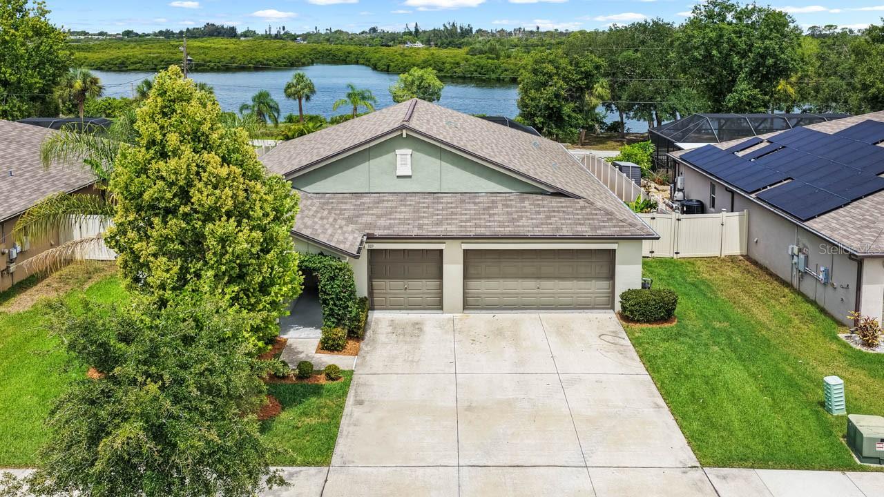 This immaculate 4-bed + OFFICE/DEN, 3-bath, 3-car WATER VIEW POOL HOME is understated from the street, absolutely unforgettable from the backyard, and anything but ordinary. Enjoy all the perks of being on water without the stress, as this lot is not in a flood zone. Features abound in this sleeper hit of the neighborhood: resort-style SALTWATER pool & spa, PAVER DECK, screened lanai, over a QUARTER-ACRE lot, covered front porch, fully fenced yard with pet-friendly turf, an organic garden, irrigation system, HURRICANE SHUTTERS, modern construction throughout (built in 2020), and breathtaking (west-facing) sunset views over the community-owned waterfront park bordering Mills Bayou. The OPEN-CONCEPT layout of this one-story Santa Fe floorplan is thoughtfully designed for flexibility, entertaining, and overall effortless living. CERAMIC TILE in all wet areas, LUXURY VINYL PLANK in the primary, and plush carpet in the other bedrooms. The expansive primary suite is located away from the secondary bedrooms in this SPLIT-FLOORPLAN layout for added tranquility, and includes a large WALK-IN CLOSET and luxurious EN-SUITE BATHROOM complete with a DUAL-SINK VANITY, shower stall, and water closet. The private guest suite would be an ideal solution for multi-generational living or extended visits with its WALK-IN CLOSET and EN-SUITE BATHROOM, and the two front bedrooms are situated on either side of the third full bathroom. The Great Room connects a dedicated office/den with a welcoming living area, dining area, and a stunning kitchen that must be every chef's dream. This incredible kitchen features STAINLESS STEEL APPLIANCES, island with BREAKFAST BAR seating, commercial-style ventilation above stove, generous prep space, and a WALK-IN PANTRY. The storage space in this home is unmatched - from the abundances of closets to the oversized garage, even the laundry room has been upgraded with cabinetry! The interior of this home truly shines from top to bottom, and the exterior is no exception. The screened saltwater pool includes a sundeck, spa, and both heater and chiller for year-round enjoyment. The west-facing backyard captures stunning sunset views over tranquil water and preserved greenery beyond. Designed for beauty without the upkeep, the yard is fully irrigated, thoughtfully landscaped, and features a raised garden bed with organic soil and mulch for homegrown herbs and vegetables. Mills Bayou is a community of 50 homes, and the association owns waterfront land visible from this home. There is a fenced dog park, a park, and a dock all available to the neighborhood residents. Domino Park Boat Ramp is only a few minutes away (less than a mile) for any boating enthusiasts. This is not a “drive-by” home — it’s a property that reveals its value once you step inside. For anyone looking for quality construction, privacy, and unforgettable sunset views, this home delivers.