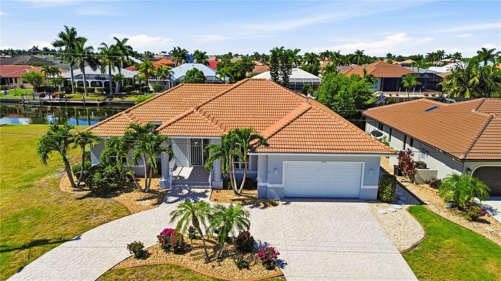 BOATING WATERFRONT, NO BRIDGES TO CHARLOTTE HARBOR, INTRACOASTAL WATERWAY, GULF AND BEYOND: Immaculate and spacious 3-bedroom, 2.5-bath pool home offering canal views in the highly desirable deed-restricted community of Punta Gorda Isles with QUICK sailboat access minutes to Charlotte Harbor and beyond. This one-of-a-kind home boasts elegance both inside and out with luscious landscaping encompassing the entire property and a circular, stamped-concrete driveway that leads to the covered, tiled front entry accented by columns and an 8-foot door with a transom window above. With a myriad of elegant features including 14' cathedral ceilings, neutral tile flooring throughout, a built-in electric fireplace, and a 4-panel pocketing sliding glass door that fills the home with an abundance of natural light. This home offers an open floor plan with a large eat-in kitchen featuring wood cabinetry, quality appliances with an induction cooktop and double ovens one of which is convection, plus a center island offering additional storage. Additional kitchen highlights include under-cabinet lighting, a breakfast bar, and an aquarium window in the dinette area overlooking the pool. The sizable family room offers a "wall" of windows providing unobstructed views of the sparkling pool and boat dock, with four pocketing 8-foot sliding glass doors allowing you to seamlessly expand your living space into your private Florida oasis. This incredible outdoor living space includes a recently resurfaced pool with a Mini-Pebble Tec finish, a freshly painted pool deck, a heated pool and spa, an outdoor pool bath, and a storage closet—all complemented by tranquil canal views. For boating enthusiasts, the private dock features a 10,000-pound boat lift with water and electric service, providing access to open water within minutes. Back inside, the primary suite is spacious with new tile flooring and triple 8-foot sliding glass doors leading to the lanai. The spa-like ensuite bath offers dual sinks, a makeup vanity, private water closet, linen closet, walk-in shower, and a separate soaking tub. A pocket door provides direct access to the laundry room, complete with a utility sink, ample storage, and convenient flow back to the kitchen. On the opposite side of the home are two generously sized guest bedrooms, both featuring new tile flooring, roomy closets, and ceiling fans. The spacious guest bath offers a linen closet, tiled shower, and private water closet. The rear guest bedroom also features double 8-foot sliding glass doors with direct access to the pool area. Additional upgrades include a complete interior and exterior repaint (2025), roof (2022), HVAC (2020), custom draperies on all sliding glass doors and dinette windows, new gravel and stepping stones on the west side of the home (2026), whole house hurricane protection, electric roll-down shutters on the front entry and three front windows, and accordion shutters on all remaining openings. Enjoy the freedom of no mandatory HOA, with optional membership to the Punta Gorda Isles Civic Association offering social clubs and community events. Minutes to St. Andrews South Golf Club, Fishermen's Village, marinas, waterfront dining, Gulf beaches, world-class fishing, farmers markets, and quick boating access to Charlotte Harbor, the Intracoastal Waterway, and the Gulf. Convenient to Punta Gorda, Fort Myers, and Sarasota airports. Don't wait, schedule your private showing today!