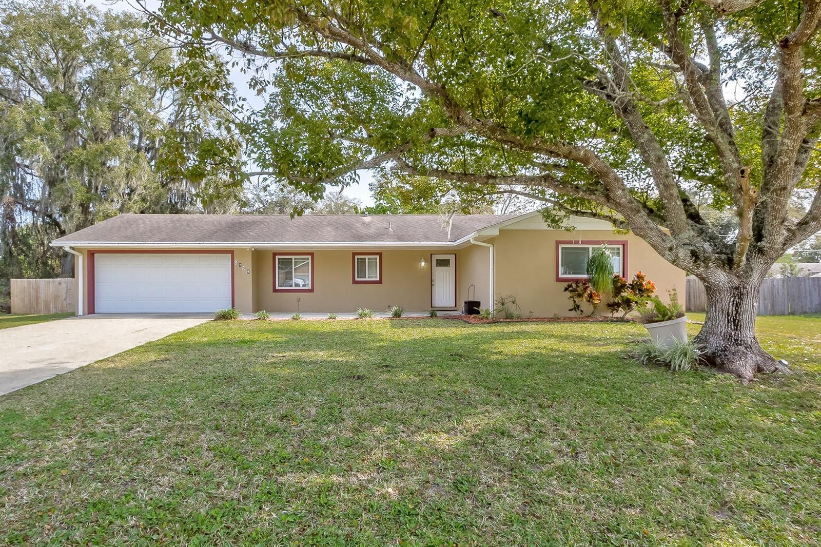 Ready to move in family home with a large fenced yard on a triple lot! Completely remodeled in 2005, this lovely home with an open floor plan has many recent upgrades, such as newer double pane impact windows, recently remodeled 2nd bath and beautiful new luxury laminate flooring throughout. Modern and open kitchen with lots of natural light, stone counter tops, stainless steel appliances, spacious breakfast bar and plenty of cabinets. Open living area with door leading to the tiled glass enclosed Florida Room which overlooks the large back yard. Spacious Master Suite with tiled shower and laminate flooring; two additional bedrooms with built-ins share the 2nd large bath. Oversized garage with step up laundry room with sink and additional storage area. Very spacious back yard with fence and solid shed, irrigation system on well. Seller will pay for one year home warranty for buyers. A great home for the family! All measurements approximate ;Water: City