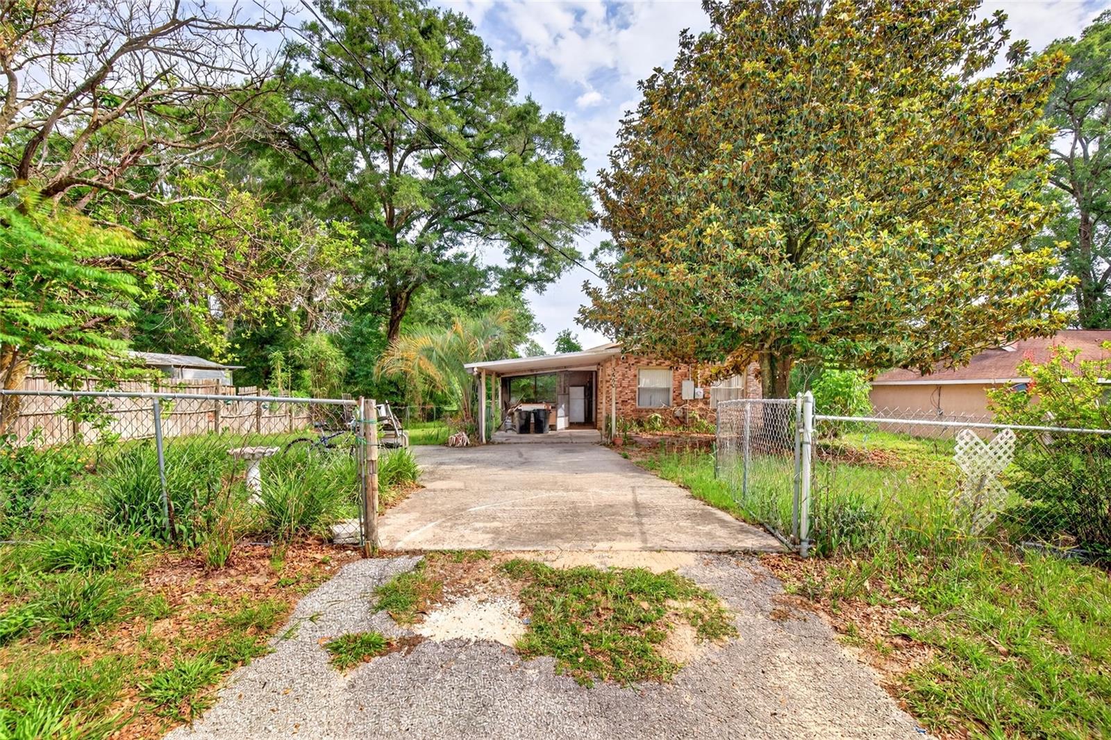 Gated and Fenced in .24 lot and you own the land, 1 car carport leads to spacious living room with tile flooroverlooking kitchen with plenty of countertop space and cabinets and dining area. Inside laundry room just off kitchen, bathroom with comfort commode and updated vanity.tub/combo shower, the 2 bedrooms are in the back of hoe, Stepping back outside to the back yard is home the the storage shed.Tile floors,  not in a flood zone and priced to sell!