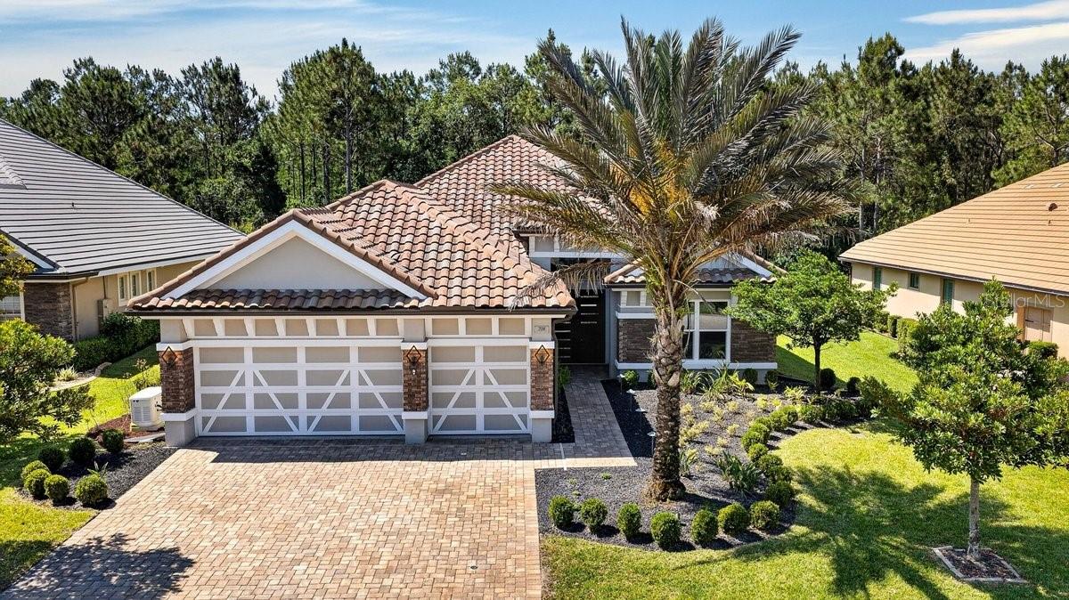 Welcome to refined living in the sought-after Woodbridge neighborhood of Plantation Bay, perfectly positioned on a quiet cul-de-sac. Built in 2021 by Kargar, this exceptional pool home blends timeless elegance with luxury Florida living. A grand, castle-style entry door sets the tone, opening to gleaming marble floors and a dramatic great room featuring soaring coffered ceilings. Expansive views immediately draw your eye to the sparkling saltwater pool with waterfall feature and the serene, private wooded backdrop beyond. Just off the foyer, a dedicated home office provides the ideal space for work or study. At the heart of the home, the chef's kitchen is both functional and impressive, offering abundant cabinetry, soft-close drawers, and a full suite of Viking stainless steel appliances, including a cooktop, refrigerator, convection oven, warming oven, and microwave. A generous 10-foot island comfortably seats four and flows seamlessly into the dining area, all overlooking the
pool. The spacious primary suite offers luxury vinyl flooring, a tray ceiling, and a spa-inspired bath finished in marble. Enjoy a soaking tub for ultimate relaxation, an oversized walk-in shower with floor-to-ceiling tile, a built-in bench, and rain shower head, along with a large walk-in closet. Two additional bedrooms are thoughtfully positioned and share a well-appointed Jack-and-Jill bath featuring dual marble vanities and a large tiled shower. Indoor-outdoor living is effortless with four-panel sliding glass doors and a retractable screen leading to a travertine-tiled lanai. The summer kitchen is equipped with a Blaze gas grill and granite countertops, perfect for entertaining. The heated saltwater pool includes a beach-style entry and is complemented by a separate four-person spa, ideal for relaxing evenings under the stars. Additional highlights include a three-car garage with epoxy flooring and ample storage, whole-house water filtration system, irrigation well, Generac generator, and landscape lighting. Located within Plantation Bay, a gated golf community known for its beautifully maintained grounds and resort-style amenities, residents have the option to join a private club featuring 45 holes of championship golf, tennis, pickleball, fitness facilities, spa services, and multiple dining venues. Conveniently situated between Daytona Beach and St. Augustine, this community offers both privacy and accessibility to coastal attractions.