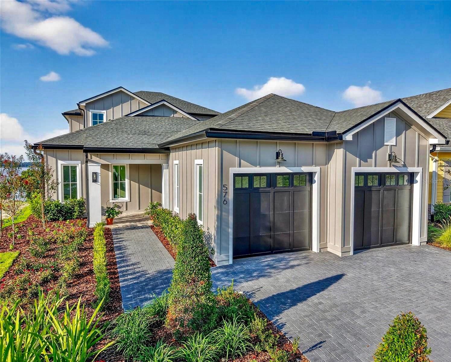 Virtually Staged. AVAILABLE FOR IMMEDIATE OCCUPANCY!  Welcome to The Kalorama, your chance to enjoy easy, inspired living in Mount Dora’s LAST EVER Downtown Custom Home Community.

From the moment you arrive, the home’s warm farmhouse style and welcoming design set the tone for relaxed, everyday comfort. Inside, open, light-filled spaces, high ceilings, and thoughtfully chosen finishes create an atmosphere that feels both elevated and effortlessly livable.
Life here naturally flows outdoors. Start your mornings or wind down in the evenings on the expansive lanai, where peaceful views of Lake Dora stretch endlessly in front of you. The home is designed so those same views follow you throughout; whether you’re relaxing in the great room, unwinding in the primary suite, or enjoying time upstairs in the loft or second suite.

At Cottages on 11th, the lifestyle extends far beyond your front door. Leave the car behind and take a short stroll into downtown Mount Dora, where tree-lined streets lead you to local boutiques, cozy cafés, and an ever-changing mix of dining spots. Weekends fill easily with festivals, live music, waterfront sunsets, and seasonal celebrations, all just steps from home. With only twenty-seven residences, this intimate community offers a rare blend of connection, charm, and comfort. Surrounded by homes that reflect the character of Mount Dora’s beloved Historic District, you’ll enjoy a setting that feels both timeless and uniquely yours!