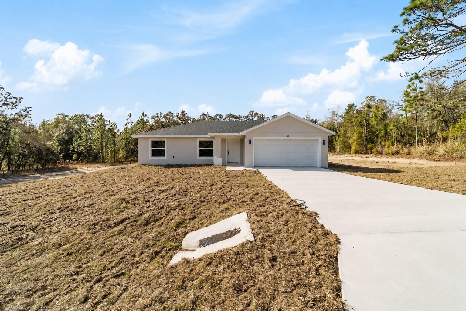 Welcome home to the perfect blend of modern comfort and peaceful country living. Nestled on a private 1-acre homesite, this beautifully finished home offers the space, quality, and freedom you've been looking for—without the restrictions of an HOA. Step inside and you'll immediately appreciate the bright, open floor plan, soaring vaulted ceilings, and beautiful luxury vinyl plank flooring that flows seamlessly throughout this split plan 3 bedroom 2 bath home. The heart of the home is the stunning kitchen, thoughtfully designed with granite countertops, white shaker soft-close cabinetry, stainless steel appliances, and plenty of workspace for cooking, gathering, and making memories. The spacious primary suite is a relaxing retreat featuring a large walk-in closet and a beautifully appointed bath with a tiled walk-in shower and glass enclosure. The guest bathroom is equally impressive with a porcelain soaking tub surrounded by designer tile, creating a fresh, upscale feel throughout. An inside laundry room adds everyday convenience and extra storage. Step outside and enjoy what makes this property truly special. With a full acre to call your own, there's room to garden, watch the wildlife, enjoy morning coffee on the porch, or simply relax and take in the quiet surroundings. Whether it's birds visiting the yard, deer wandering nearby, or peaceful evenings under the stars, this is the kind of setting that's becoming harder to find. Located just minutes from Rainbow Springs State Park, you'll have endless opportunities for kayaking, tubing, swimming, fishing, hiking, and enjoying Florida's natural beauty. The nearby Rainbow Lakes Community Center offers tennis courts, basketball, racquetball, baseball fields, and a playground, providing recreation for all ages. Downtown Dunnellon is just a short drive away for shopping, dining, and everyday conveniences. If you've been searching for an affordable home that combines beautiful finishes, modern design, a spacious homesite, and a peaceful lifestyle close to nature, this home deserves a place at the top of your list. Owner financing is available.