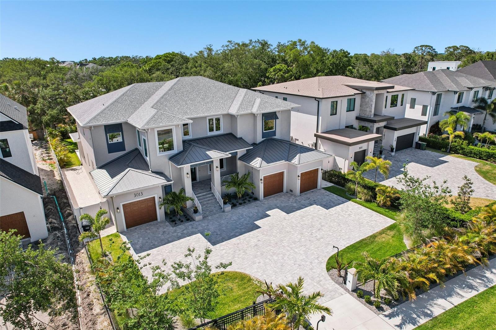 BRAND NEW luxury home located in a newly developed area of privately gated estate homes on a rare 0.40-ACRE LOT. Constructed by the well-respected builder, Kingfisher Development, this home is a fortress built with solid block construction, impact rated doors and windows situated on one the largest lots you will find offering you a beautiful private and QUIET oversized backyard.  Step through the double doors into the oversized foyer with 22 ft ceilings and attractive cable railing staircase and you will immediately notice how this home is flooded with natural light and designed with a transitional style that will fit any décor.  The front living room has beautiful ceiling detail, is adjacent to the glass enclosed wine room and dry bar and could be used as a formal dining room if that is your preference.  Adjacent to the living room is the home office/den with an attention getting custom accent wall. The spacious great room is open to the eat-in kitchen with a Wolf gas range, paneled front SubZero refrigerator, walk-in pantry and custom designed two-toned wood cabinetry with attractive brass hardware.  The floor plan includes a private guest bedroom suite on the first floor with the primary bedroom located on the second floor along with 3 additional bedrooms (all with ensuite baths), a large bonus room with wet bar and built in shelves PLUS an additional bonus room that could be used as an office/nursery/craft room, additional master closet space or easily accessible air-conditioned storage. There are large laundry rooms on both floors for your convenience.  You will want to spend as much time outside as inside on the oversized back tranquil covered lanai enhanced with Bahama shutters, stained wood ceilings and travertine flooring. This space has been well designed to include two distinct seating areas, one where you can gather in front of the outdoor gas fireplace and upscale outdoor summer kitchen, and the other adjacent to the 10-person elevated spa. The spa overflows to the pool with a splash deck and all overlooks the oversized fully fenced and landscaped backyard. You will be safe and secure behind an electronic front gate and have ample off-street parking on the oversized front brick paver driveway.  The 4-car garage has electric car charging outlets, the entire home has been pre-wired for a whole house generator and pre-wired for all your technology, security audio/visual needs.