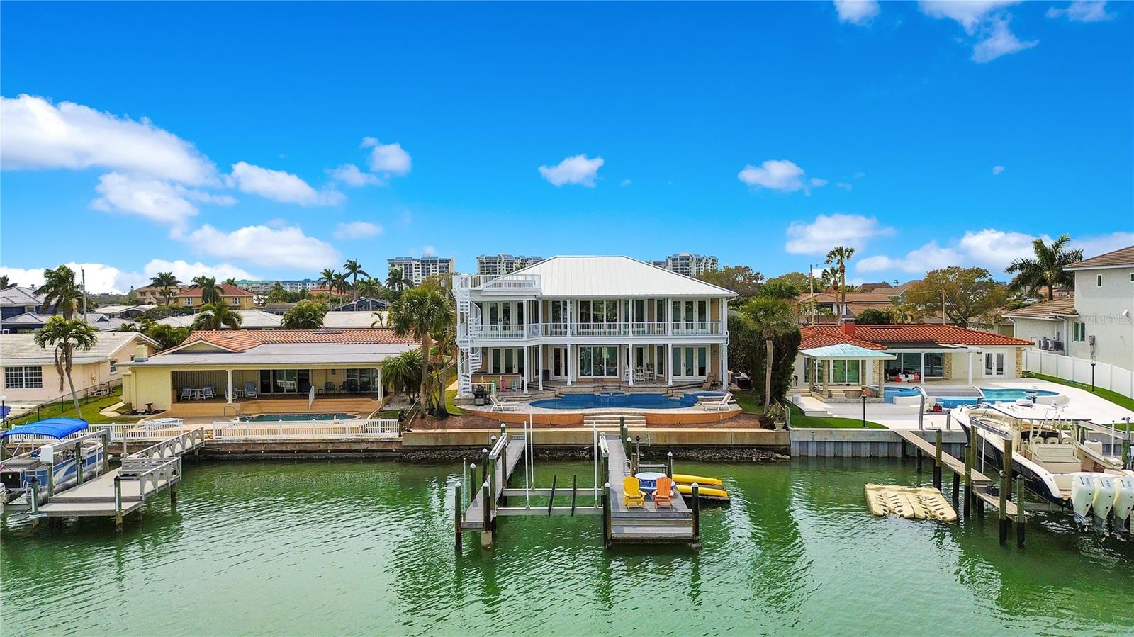 Nestled within the highly sought-after Yacht Club Estates boating community, this Key West style residence epitomizes the allure of waterfront living. Boasting 5 bedrooms and 4.5 bathrooms, this estate stands as a testament to the luxurious Florida lifestyle, while offering a vast array of impressive features and amenities throughout. This style of architecture exudes the utmost charm, while the lush landscaping sets the stage for what lies within.As you step inside, prepare to be captivated by the grandeur of an expansive great room. Here, the sweeping water vistas greet you through the spectacular wall of windows, inviting the beauty of the waterfront indoors. With soaring 22-foot ceilings, experience an air of spaciousness bathed in natural light. Immediately adjacent to the great room lies the heart of this home…the gourmet kitchen. Meticulously designed to cater to the most discerning chef, the kitchen boasts gleaming countertops, custom cabinetry, and high-end appliances, while a generous pantry ensures ample storage for all of your culinary delights. After dinner, head upstairs to the loft and game area which offers scenic views of the intracoastal waterway. Each of the 5 bedrooms is designed to provide a haven of tranquility, with the master suite standing out as a true sanctuary. Complete with a lavish bathroom and access to a spacious covered deck, it offers panoramic views of Tampa Bay, inviting you to unwind in absolute serenity. Outside, the impeccably landscaped grounds beckon you to enjoy the outdoors in style. A PebbleTec saltwater pool and spa offer a refreshing escape from the Florida sun, while a tranquil fountain adds a touch of elegance to the surroundings. Host “talk-of-the-town summer pool parties on the custom deck, or lounge peacefully at sunset while overlooking the picturesque waterfront. With direct access to the Gulf, this home epitomizes the ultimate waterfront lifestyle. Whether you're enjoying a leisurely boat ride, sunbathing by the pool, or simply taking in the breathtaking views, every moment spent here is an experience to cherish. It’s the perfect retreat for those seeking the pinnacle of waterfront living.