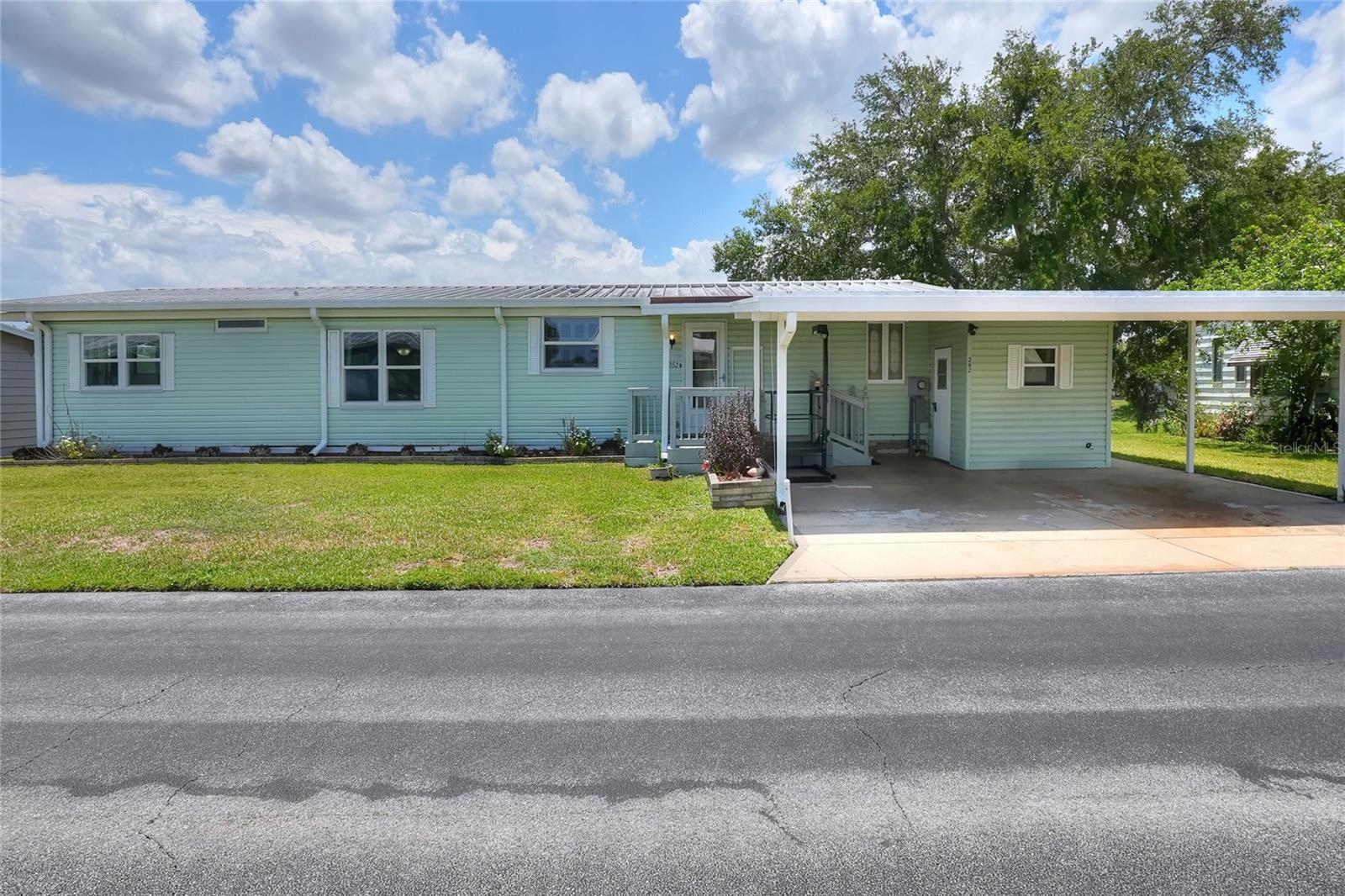 Welcome to your ideal waterfront retreat in Bartow’s premier 55+ Floral Lakes community! Situated directly on Boca Cove, this move-in-ready 2-bedroom, 2-bathroom manufactured home offers the ultimate perk of true land ownership, meaning you own your land with no lot rent and low monthly HOA fees. Built for comfort and efficiency, the home features energy-saving double-paned windows and sliding doors, a newer A/C unit, and a durable metal roof. Inside, the heart of the home is a spacious kitchen equipped with an island cooktop, built-in oven, dishwasher, a handy breakfast bar, and plenty of cabinetry for all your pantry needs. A separate dining area features a built-in lighted china hutch, flowing naturally into a large living room where sliding glass doors open directly into a comfortable, air conditioned enclosed Florida room.
Designed with a desirable split-bedroom layout for maximum privacy, the primary suite serves as a peaceful escape, boasting its own sliding glass door to the Florida room, double vanities, double linen closets, and a fiberglass shower. On the opposite side of the home, the second bedroom features an oversized walk-in closet and en suite access to the guest bathroom, which includes a large vanity and a classic tub/shower combo. Conveniently located just off the kitchen, the dedicated laundry area comes complete with a utility tub, washer, and dryer. Outside, the property is highly accessible, featuring a double carport equipped with a wheelchair lift for easy entry, a functional workshop/storage room, and an additional screened storage area tucked away in the rear.
The standout feature of this property is the spacious private wooden dock out back, giving you the perfect spot to fish Boca Cove or park your boat right at home. Located in the heart of Central Florida between Tampa and Orlando, this golf-cart-friendly neighborhood places you just minutes from the Bartow Civic Center, Bartow Public Library, and Mary Holland Park. Residents of Floral Lakes enjoy a vibrant, active lifestyle with access to a clubhouse, a large heated swimming pool, a putting green, shuffleboard courts, a stocked community pond, and a boat ramp, alongside a packed calendar of social clubs, dances, and potlucks. Please note that association approval is required for purchase. Don't miss this exceptional waterfront opportunity—call your Realtor today to schedule your private showing!