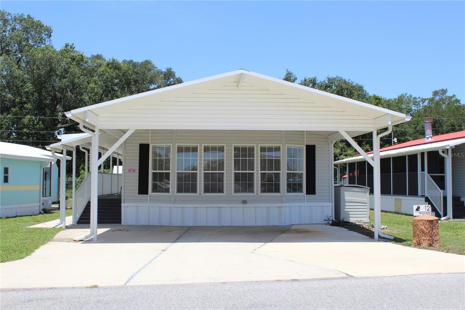Located in the highly sought-after 55+ gated community of Saddlebag Lake Resort, this beautifully maintained Jacobsen 2-bedroom, 2-bath manufactured home is being offered fully furnished and is ready for you to enjoy from day one.

Designed for both comfort and convenience, the home features attractive Pergo laminate flooring throughout the main living areas, offering style and easy maintenance. For added peace of mind, a whole-house generator powered by either gas or propane ensures reliable backup power during any weather.

The well-appointed kitchen is equipped with a full suite of stainless-steel appliances, including a glass-top range, double-door refrigerator with ice maker and water dispenser, dishwasher, and microwave. Adjacent to the kitchen, the dining area features a table and chairs and a built-in cabinet, adding both character and convenient storage.

One of the home's standout features is the spacious bonus room at the rear, providing the perfect space for a home office, craft room, hobby area, or additional living space.

Outside, you'll find even more to love. A two-car carport offers ample covered parking, while a full-length covered walkway with durable composite decking leads to a relaxing, screened porch overlooking the backyard—an ideal spot to enjoy your morning coffee or unwind in the evening.

Outside, you'll find even more to love. A two-car carport offers ample covered parking, while a full-length covered walkway with durable composite decking leads to a relaxing screened porch overlooking the backyard—an ideal spot to enjoy your morning coffee or unwind in the evening.

The low HOA fee includes water, sewer, garbage collection, and access to an impressive array of resort-style amenities. Residents enjoy a welcoming clubhouse with planned social activities, a sparkling community pool, screened hot tub, covered professional-grade shuffleboard courts, tennis and pickleball courts, horseshoe pits, and a recreation center featuring pool tables, fitness equipment, and a sauna.

Outdoor enthusiasts will appreciate boating and fishing on beautiful Saddlebag Lake, relaxing on the community beach, or reserving the beach house for private gatherings. The pet-friendly community also features a dedicated dog park conveniently located near the driving range. Additional conveniences include an on-site post office and library.

If you're looking for an active, carefree Florida lifestyle in a vibrant waterfront community, this exceptional home checks all the boxes.
Schedule your private showing today—this exceptional home won't last long, and you won't want to miss the opportunity to make it yours!