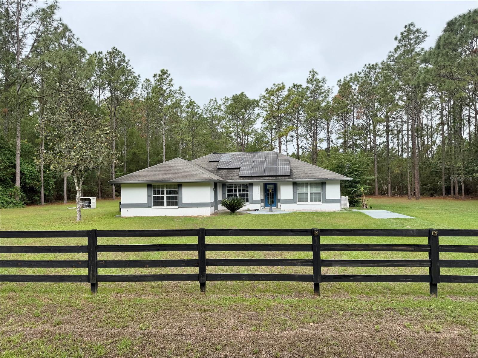 $15,000 buyer incentive! Enjoy the space and charm of this 3-bedroom, 2-bath concrete block home with a bonus room, built in 2003 on 2.5 acres in the Oak Ridge Crossing neighborhood. The kitchen boasts quartz countertops with a stylish waterfall accent, while the great room features beautiful "wood-look" tile flooring. The primary bedroom offers a walk-in closet, and its en-suite bath showcases updated tile & shampoo niche in the shower. The bonus room, with its own entrance, can double as a den or study. A screened porch with ceramic tile flooring overlooks the spacious yard, with ductwork ready for heating or cooling if enclosed. There’s also covered parking for a car, boat, or RV. Located in a quiet, home-only subdivision of just 32 homes, it’s minutes from Gainesville and I-75. Fiber optics & cable available. A solar panel feeding to Duke energy along with a well and septic utilities, add modern convenience and savings. Ready for quick closing and occupancy. 1 year home warranty included.