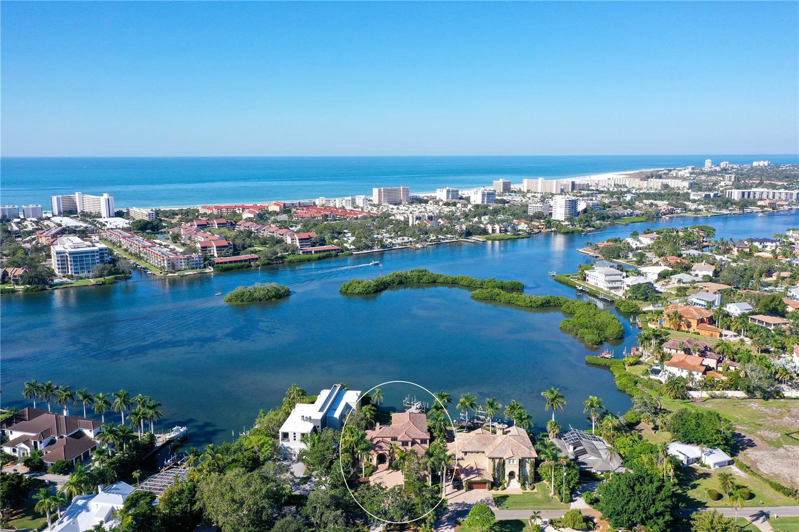 Nestled in the prime spot of Sarasota, just a stroll away from Siesta Key, this stunning Bayfront residence occupies its own serene enclave on Little Sarasota Bay, seamlessly connected to the Intracoastal Waterway. Tucked away at the end of a secluded road, the house boasts ample front and back lawns, offering exceptional sunset panoramas. 

The main floor hosts a waterside office and three bedrooms, including the master, with one room versatile enough to serve as an exercise space. Upstairs, two additional bedrooms accompany a generously sized game room and a theater room boasting a 12-foot-wide screen. A broad dock equipped with a boat lift and jet ski pair lifts, offering over three feet of depth, provides easy water access with steps for convenient kayak entry. This custom-designed floor plan maximizes outdoor living, boasting over 7,000 square feet under roof across both levels.

Indulge in the allure of the pool and spa area featuring a waterfall, authentic stone flooring and columns, granite countertops, top-of-the-line plumbing fixtures, and stainless appliances from Wolf and Subzero. Italian roof tiles, an office complete with a wet bar, and a spacious upstairs game room with a bar area leading to a large upper deck further enhance this luxurious abode. The downstairs covered lanai invites outdoor dining with a screened eating area and an outdoor kitchen featuring high-bar seating.

With 14-foot-high ceilings throughout the main and upper levels, this home also features a 3-car garage, a lawn sprinkler system utilizing a water well, and complete hurricane protection including Cleartek window shields, Crimesafe screens, and built-in sliding door shutters.