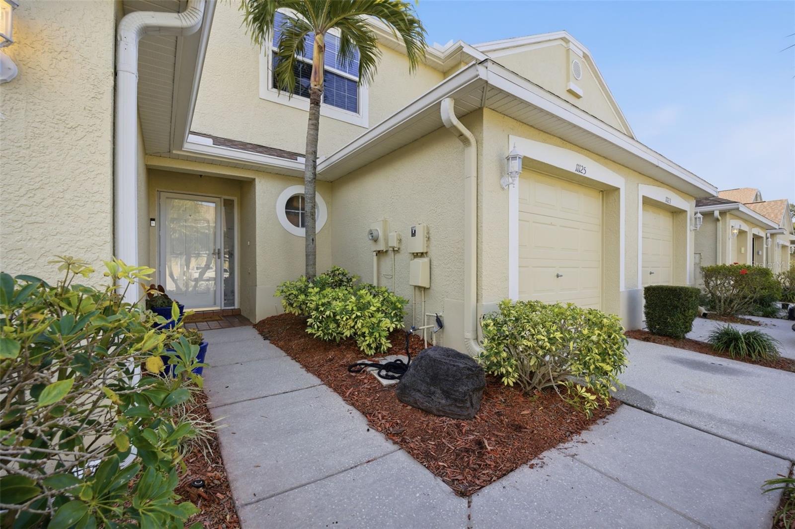 Located in the desirable Kapok Grand community, this beautifully maintained townhome offers a rare and tranquil rear pond view enjoyed by only a select number of homes, with mature elm trees, birds, turtles, and peaceful natural scenery creating a truly serene setting from the private back screened-in lanai. Inside, the home feels open and airy with extra-high ceilings downstairs and vaulted ceilings upstairs, while still offering a warm and inviting atmosphere ideal for everyday living and entertaining. The spacious kitchen features stainless steel appliances, a brand-new high-end range, and a generous eat-in area, flowing seamlessly into the main living space. Both bedrooms include private bathrooms, with the convenience of an upstairs laundry room easily accessible from the bedrooms. The community is impeccably maintained with lush landscaping, irrigation, and pruning, and residents enjoy easy access to a clubhouse, fitness center, and pool, all a short distance across the street, and all supported by a low monthly HOA fee. Ideally situated near Madeira Beach, shopping, dining, and major roadways, this home offers a rare blend of location, lifestyle, and peaceful views in one of the area’s most well-kept communities.