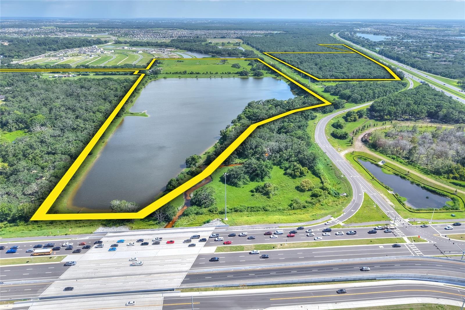 Positioned at one of Tampa Bay’s most dynamic growth corridors, this rare 117± acre offering lies at the high-visibility intersection of I-75 and Big Bend Road in Riverview, Hillsborough County. Its unmatched scale, access, and location make it an exceptional candidate for major sports, recreational, medical, educational, or community-based developments. Included within the property are 12 developable acres ready for up to 188 residential units or 50,000–75,000± square feet of non-residential use.

Beyond its development opportunities, the land offers a park-like setting just minutes from the interstate yet remarkably private. A scenic 30± acre lake, Bullfrog Creek meandering through oak hammock preserves, and wide stretches of open pasture provide a rare balance of recreation, natural beauty, and long-term investment value.

As one of the last large acreage tracts available in Tampa’s core growth corridor, and with significant residential and commercial expansion already underway nearby, this property represents a true crossroads of lifestyle and opportunity.