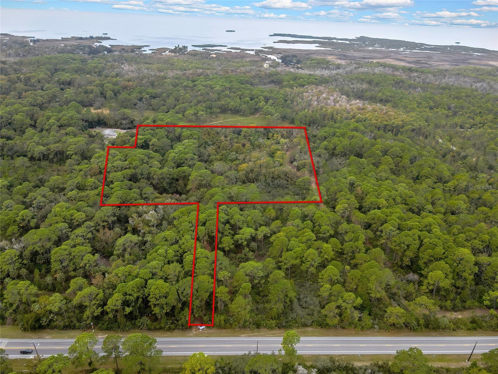 This exceptional 9.80acre parcel offers a rare combination of flexibility, development potential, and immediate access to Florida’s preserved lands—making it an ideal location for a premier hunting camp, outdoor retreat, or a small-scale residential subdivision. Zoned R-1A Residential, the property allows both conventional single-family homes and manufactured housing, giving buyers and developers, a wide range of options. The western boundary adjoins protected conservation land, ensuring permanent privacy, abundant wildlife corridors, and year-round hunting and wildlife watching opportunities right from your back door. With a minimum lot size of just 6,000 sq. ft., this land can easily be subdivided into multiple home sites, making it highly appealing for residential development or maintained as a private
hunting compound. The property is accessed via a 20foot easement from Shoal Line Boulevard, providing a comfortable setback from the roadway while maintaining convenient accessibility. This offering encompasses two parcels—Key Number 374473 (4.00 acres) and Key Number 374428 (5.80 acres)—sold together for a total of 9.80 acres. R-1A zoning permits accessory uses such as garages, carports, and outbuildings that are perfect for equipment storage, game processing facilities, bunk cabins, or workshops. Special exceptions are available for home occupations and bed and breakfast establishments, and favorable dimensional standards, including modest setbacks and a minimum dwelling size of only 600 sq. ft., further enhance design flexibility for creating a rustic camp, sportsman’s
enclave, or a cluster of custom homes. Adding practical convenience, Hernando County records show a plan for a general store located
across Shoal Line Boulevard from the parcel. Picture a thoughtfully designed country store and outfitters hub steps from your gate—serving camp guests, nearby residents, and outdoor enthusiasts with supplies, bait and tackle, local provisions, and a community gathering spot after a day in the field or on the water. Having a store so close elevates the property’s appeal as a turnkey hunting camp or weekend retreat and supports blended uses that enhance revenue and guest experience. The parcel sits in the Weeki Wachee area, home to some of Hernando County’s most treasured parks. Just minutes away are Alfred McKethan Pine Island Park, Bayport Park, Jenkins Creek
Park, and Linda Pedersen Park where residents can enjoy beaches, boating, fishing, boardwalks, and manatee viewing. This unique combination of preserved land access for hunting, nearby worldclass fishing, and close by commercial convenience creates an outdoor
enthusiast’s dream property. Whether you are a developer looking to maximize the land’s potential, a hunter seeking private access to protected game lands, or an entrepreneur building an off-grid retreat with a community hub, this 9.80acre parcel is a rare find where Florida’s wild beauty meets practical opportunity.