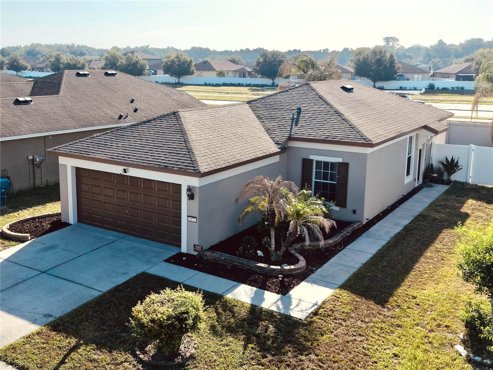 Experience the ease of Suncoast living in the Trillium Community, which features a stunning community pool and affordable HOA fees of just $97 per month. This move-in ready residence boasts 3 bedrooms and 2 bathrooms, complemented by a 2-car garage and a well-designed 1,260 sf split-bedroom layout that promotes low-maintenance living. The bright living room seamlessly connects to an outdoor patio and a spacious VINYL PRIVACY FENCED backyard, ideal for relaxation, entertaining, or providing a safe play area for children and pets. The EAT-IN KITCHEN is equipped with espresso-colored wood cabinets, recessed lighting, ample counter space, a BREAKAST BAR with a pass-through, PANTRY storage, and stainless steel appliances, including a stove with Wi-Fi and air fryer capabilities. The primary suite features a WALK-IN CLOSET and an ensuite bathroom with a STEP-IN SHOWER, while bedrooms 2 and 3 share a full bathroom that also serves as an ensuite for bedroom 2. Additional conveniences include an INTERIOR LAUNDRY closet with a WASHER & DRYER, and durable vinyl tile flooring throughout the home, which was freshly painted both inside and out in 2025. The location is exceptional, with Trillium situated next to the Suncoast Parkway for easy access to Tampa, along with nearby shopping, dining, and schools. Community amenities include a resort-style pool, playground, dog park, and a bike/walking trail that leads to Anderson Snow Park. The floor plan is available in the accompanying photos.