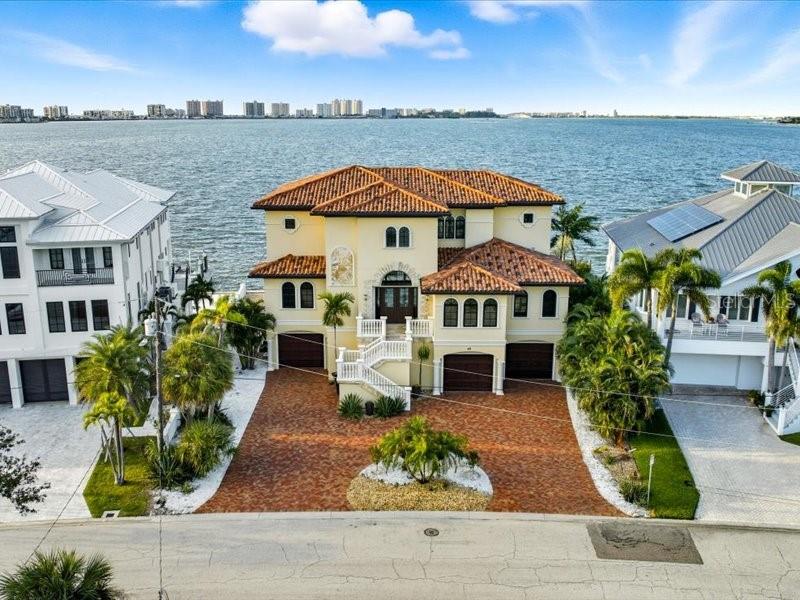 Located at 42 N Pine Circle one of Belleair’s most prestigious streets, this custom-built 2016 residence showcases breathtaking open water views and timeless craftsmanship. Featuring 4 bedrooms, 3 full baths, and 2 half baths, the home offers an elegant balance of luxury and comfort.
The designer chef’s kitchen is equipped with top-of-the-line appliances and opens to spacious living and dining areas—perfect for entertaining. A newly refinished pool and spa overlook the water, creating a serene outdoor retreat overlooking the open views and new seawall 7/2024. 
Inside, the fresh paint highlights the rich dark wood trim and floors, beautifully contrasted by light-edged travertine throughout. High-end finishes abound, including an iron staircase, custom iron chandeliers, and artful wall sconces, fireplaces, primary bedroom overlooking the intracoastal.  The home includes three jacuzzi bath tubs in all of the ensuite bedrooms.  The expansive balconies and disappearing sliding doors blur the line between indoor and outdoor living on the huge balconies.
An elevator conveniently serves all three levels of the home, including a full under-home garage that accommodates three or more vehicles with ease. This exceptional property combines sophisticated design, modern convenience, and the finest Belleair waterfront living.