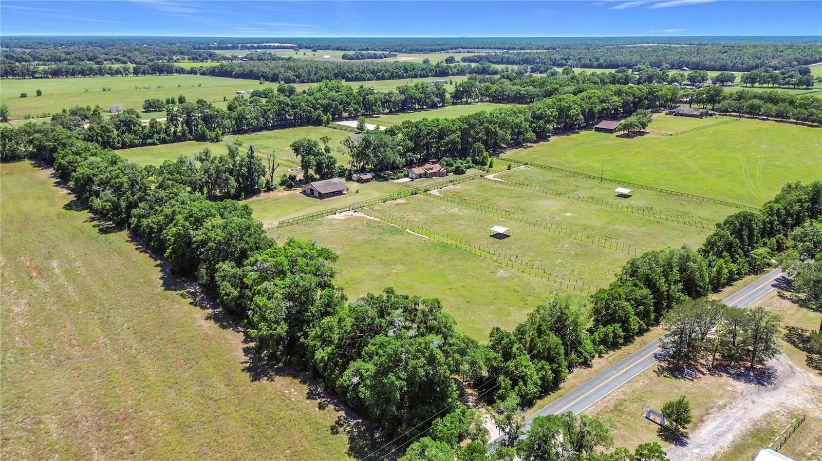 Overlooking 19+ acres to the North end of Dunnellon, this versatile farm offers a great combination of privacy and potential– all with no HOA restrictions! Conveniently located just around the corner from US 41 and a short drive from both the World Equestrian Center, HITS, and Ocala’s variety of shopping and dining options, this farm is perfectly positioned to get the most out of Central Florida’s exciting equestrian lifestyle. Designed for both efficiency and flexibility, the property features a 12-stall center-aisle barn complete with feed and tack rooms, 5 pastures/paddocks, and lush bahia grass fields that were previously used for hay production. Whether your focus is training, boarding, or passive seasonal rental income, the farm is well suited for a variety of uses, skill-levels, and disciplines with ample opportunity to further customize if desired. Two residences are currently established on property: The main home is a 3-bedroom, 2-bath block home with over 1,300 sqft of space. Updates to this home include a new roof in 2024 and new HVAC in 2022. The secondary home is a 3-bedroom, 2-bathroom mobile home built in 2015, offering plenty of flexibility for guests, in-laws, or potential rental income. This would be a great option for those looking to take advantage of the local equestrian and outdoor tourism with an AirBnb or VRBO with Rainbow Springs State Park, the Rainbow River, and the Goethe State Forest just minutes away. With no HOA, established infrastructure, and multiple opportunities for income through boarding, seasonal rentals, or Airbnb/VRBO potential, this is a rare opportunity to own a centrally located farm in one of Marion County’s most desirable equestrian corridors!