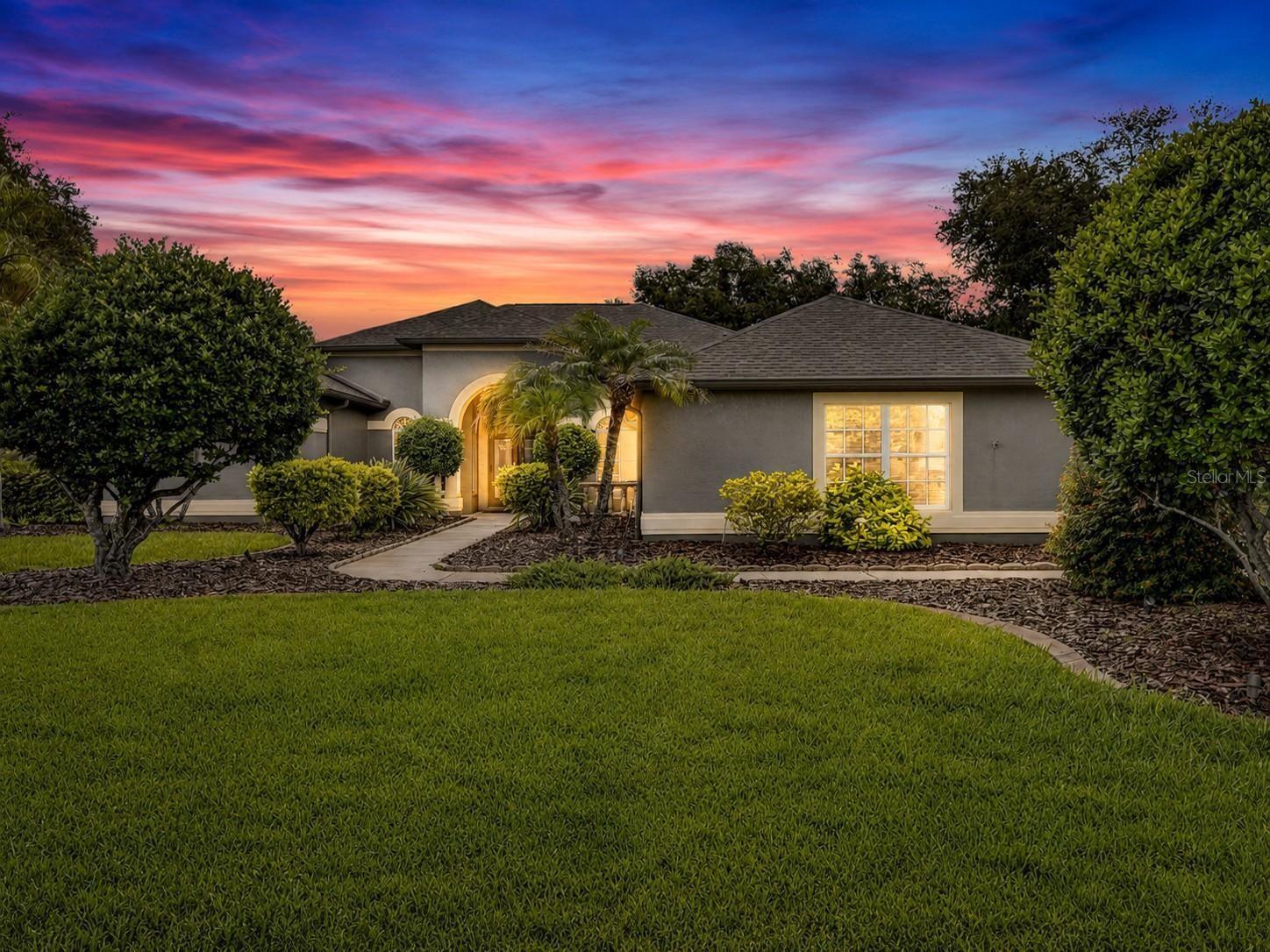 This beautifully customized Avalon model by Centex Homes is perfectly positioned on an oversized .78 acre lot with peaceful pond views in the highly sought-after Montreux community. Custom built by its original and only owner, this meticulously maintained residence reflects years of exceptional care, thoughtful upgrades, and pride of ownership. Ideally located with convenient access to the Suncoast Parkway and situated within a highly acclaimed school district, this exceptional home offers the perfect blend of quality construction, timeless design, and modern comfort. Built with a steel-reinforced concrete foundation and concrete block exterior walls, the home showcases lasting durability and meticulous attention to detail throughout. From the custom specialty front doors to the elegant combination of composite hardwood flooring, ceramic tile, and plush carpeting, every space has been thoughtfully designed. Crown molding, recessed lighting, and energy-efficient SunTek window film further enhance the home's refined interior. At the heart of the home, the beautifully appointed kitchen is both functional and inviting, featuring 42-inch Maple Spice cathedral cabinetry with rollout drawers, granite countertops, stainless steel appliances, a double electric oven, a spacious center island, a charming breakfast nook, and sliding doors that open seamlessly to the screened lanai. A custom-built office with integrated cabinetry, upper glass display cabinets, and enhanced lighting provides the perfect work-from-home space. The leisure room is designed for gathering and relaxation with its custom entertainment center, gas fireplace, and built-in surround sound system. The spacious owner's suite offers a private retreat with sliding doors leading directly to the pool deck, a custom California Closet system, and a luxurious en-suite bath featuring a large 6 foot soaking tub, oversized walk-in shower, and private water closet. Outside, your own backyard oasis awaits with a screened lanai, sparkling pool and spa, privacy wall, new pool heater (2026), and rooftop solar panels dedicated to pool heating, extending your enjoyment throughout the year. Additional highlights include a spacious laundry room with built-in cabinetry and folding counter, a side-facing three-car garage with epoxy-coated floors, extra storage space, service door, and elevated air handler, along with a built-in Pest Defense System, automatic sprinkler system, a new roof (2019), and a new 3-ton Rheem HVAC system (2024). Combining premium upgrades, exceptional craftsmanship, and an unbeatable location, this lovingly maintained home presents a rare opportunity to own a true one-owner residence in one of the area's most desirable communities.