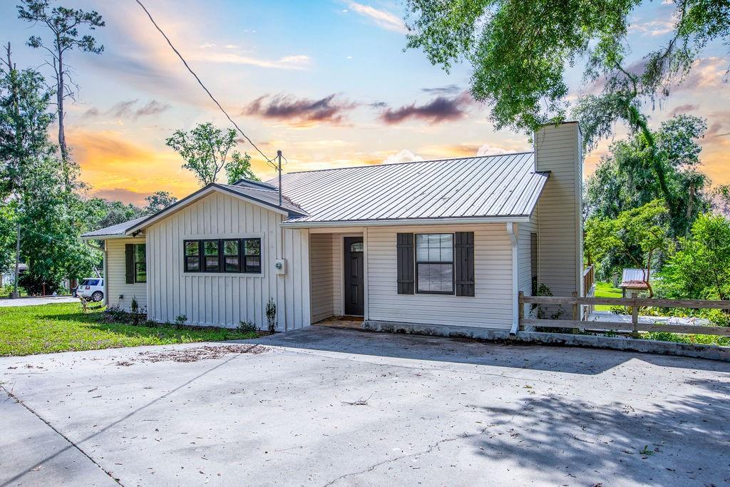 Welcome to 11274 71st Drive in Live Oak, Florida—a peaceful lakeside home that offers comfort, space, and a connection to nature. Built in 1986 and thoughtfully updated, this single-story home features 3 bedrooms, 2 bathrooms, and approximately 1,852 square feet of living space. As you approach the property, you'll notice the home's sturdy frame with vinyl siding and a durable metal roof, ensuring longevity and low maintenance. The irregular lot provides a unique landscape, complemented by partial rain gutters and a driveway that accommodates multiple vehicles. The backyard opens up to approximately 50 feet of lake frontage on Peacock Lake, offering a serene setting for fishing, kayaking, or simply enjoying the view. Stepping inside you'll see that natural light floods the interior, highlighting the vinyl plank flooring that runs throughout the home. The living room serves as the heart of the home, featuring a wood-burning stove that adds both charm and warmth during cooler evenings. Ceiling fans are thoughtfully placed to ensure comfort throughout the year. The kitchen is equipped with essential appliances, including a refrigerator, microwave, dishwasher, electric stove, washer, and dryer. Granite and wood countertops provide a blend of durability and rustic appeal. Adjacent to the kitchen, the dining area offers a comfortable space for family meals and gatherings. The home boasts three well-sized bedrooms, each designed with comfort in mind. The two full bathrooms are conveniently located, featuring practical fixtures and finishes that cater to everyday needs. The enclosed porch offers a versatile space, perfect for hobbies, reading, or simply enjoying the view of the lake. Additional features include a heat pump system for heating and cooling, internet-DSL and TV satellite connections to keep you connected, and a laundry room located inside for convenience. The property is part of the Peacock Lake subdivision, offering a sense of community while maintaining privacy. This home is more than just a place to live; it's an opportunity to embrace a lifestyle that values tranquility, nature, and comfort. Whether you're seeking a permanent residence or a weekend getaway, this lakeside retreat offers the perfect balance. Don't miss the chance to make this charming home your own. Schedule a viewing and experience the serenity of 11274 71st Drive, Live Oak, FL 32060.