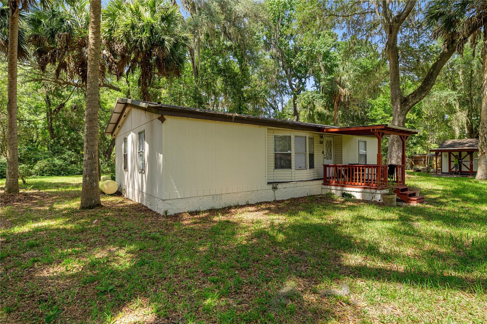 Welcome to 3424 NE 162nd Street, Citra, Florida—a rare opportunity to own an established turnkey short-term rental or a peaceful full-time residence that feels like your own private vacation retreat. Situated on .76 acres overlooking a pond with a private dock, this beautifully maintained 2-bedroom, 2-bathroom home offers the perfect blend of relaxation, income potential, and the Florida lifestyle buyers are searching for.

Each spacious bedroom features its own walk-in closet, providing comfort and privacy for owners and guests alike. The home is being offered fully furnished and professionally staged, as it is an active, income-producing short-term rental with current bookings already in place. Simply step in and continue welcoming guests from day one, or, if you’ve been dreaming of a move-in-ready home, just bring your toothbrush—everything else is already here.

Designed for both entertainment and relaxation, the outdoor living spaces truly set this property apart. Enjoy your morning coffee while watching the sunrise over the pond from your private dock, unwind under the peaceful canopy of mature trees, or challenge family and friends in the detached recreation building filled with games. A separate storage shed offers the perfect place to keep tools, lawn equipment, or supplies for managing the property with ease.

Built in 1992, this charming home combines peaceful country living with convenient access to some of North Central Florida’s most desirable destinations. Located just a short drive from Ocala, Gainesville, the World Equestrian Center, Silver Springs State Park, Orange Lake, Paynes Prairie Preserve, and the Ocala National Forest, outdoor enthusiasts will love the endless opportunities for fishing, kayaking, boating, horseback riding, hiking, and exploring. Shopping, dining, medical facilities, and the University of Florida are also within easy reach.

Whether you’re looking for a proven income-producing short-term rental, a vacation home, a Florida retreat, a pond-front property, or a move-in-ready residence where every day feels like a getaway, this exceptional property delivers. Opportunities like this—offering established rental income, beautiful natural surroundings, turnkey furnishings, and an unforgettable guest experience—are hard to find. Schedule your private showing today and discover why this unique property is ready to impress its next owner.