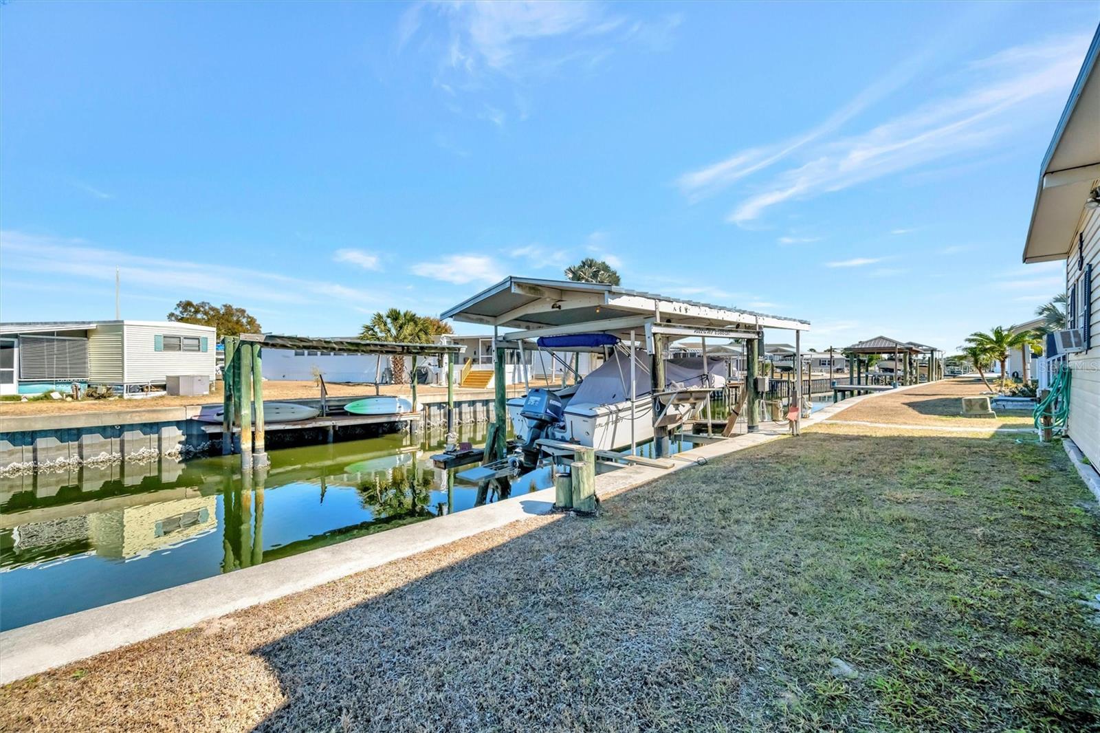 Discover relaxed Florida living in the highly desirable Caribbean Isles Residential Cooperative, a 55+ waterfront community known for its friendly atmosphere and active lifestyle. Step outside the home and step right aboard your boat with access to Tampa Bay for sunset cruises or waterfront dining. Enjoy watching manatees and dolphins from your backyard.

This 3-bedroom, 2-bath home features a stunning 25-foot eat-in kitchen that’s a dream for any home chef. You’ll love the upgraded solid wood cabinetry, stone countertops, and a large deep sink with a gooseneck faucet designed to easily handle oversized pots and pans. Updated appliances include a combination built-in convection oven and microwave, island with downdraft cooktop, refrigerator and dishwasher. Updated flooring completes this inviting kitchen space. The combined living room and dining room are flooded with natural light, enhanced by vaulted ceilings that create an open and airy feel. Luxury Vinyl flooring has been installed in the living room, dining room, and primary bedroom. The spacious primary bedroom offers a private ensuite bath, large enough to include a conveniently located laundry area tucked neatly into a built-in closet. Updated vinyl windows add both style and energy efficiency. Major system upgrades provide peace of mind, including a new outside HVAC unit, new ductwork, and new insulation and vapor barrier installed beneath the home.

If you're an outdoor enthusiast, you'll appreciate our kayak and boat launch facilities. Our canal system offers direct access to Tampa Bay. For those who enjoy friendly competitions, we have bocce ball, shuffleboard courts and horseshoes. The heated community pool is heated year-round. Inside our clubhouse, you'll discover a craft room and large game room, with pool tables, card table, indoor bar shuffleboard and darts, providing opportunities for creativity and socializing. Our community has many activities throughout the year. From themed dinners to dances, there's always something exciting happening to suit your preferences and keep you engaged year-round. Our prime location, conveniently situated between Tampa and Sarasota/Bradenton, ensures that you'll have easy access to an abundance of nearby activities. Beaches and thrilling amusement parks are just a day trip away. We invite you to pay us a visit and discover for yourself why so many call Caribbean Isles home.