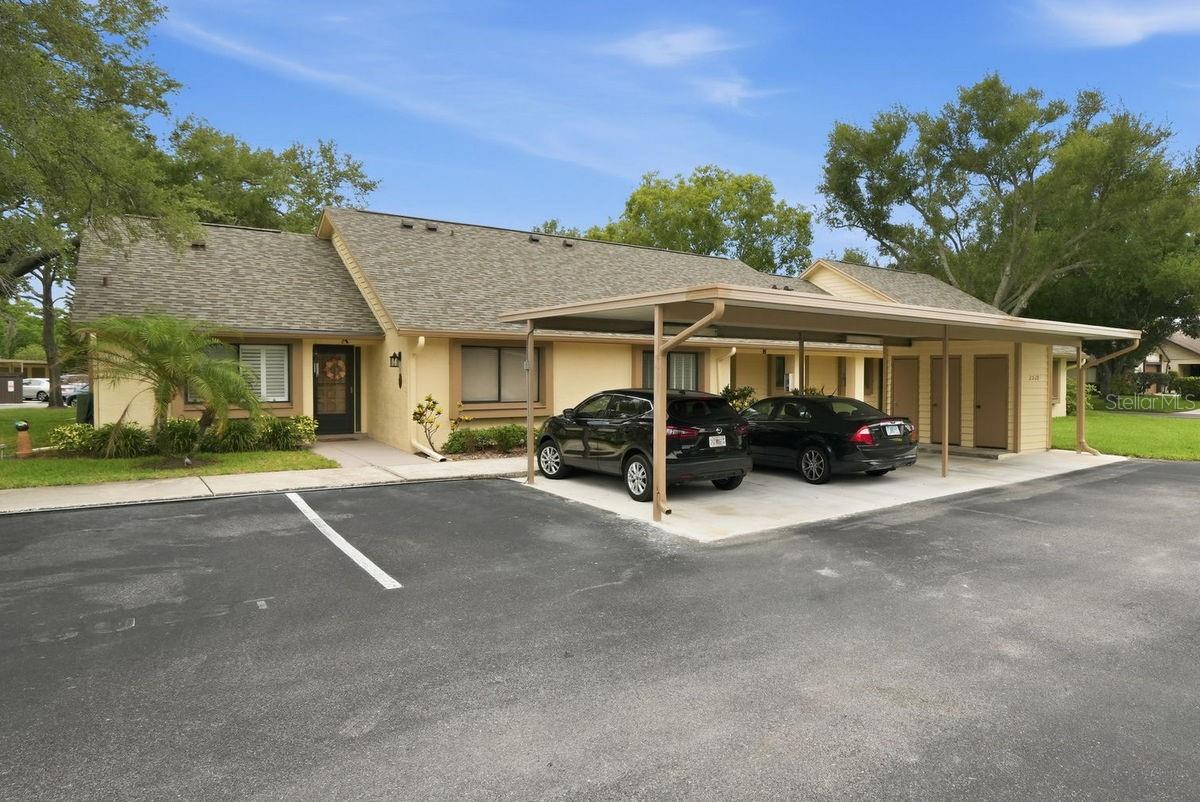 This move-in ready, tastefully furnished villa is ideally located in the sought-after 55+ community of Village on the Green... just bring your toothbrush! Property greets you with an attractive curb appeal and covered front porch. The interior features a bright, spacious, split bedroom plan that includes the following: welcoming foyer, large great room, open kitchen, master bedroom with private bath & walk-in closet, office - den or guest bedroom, 2nd full bath, separate laundry room, relaxing Florida room, PLUS a paved rear patio Perfect for your morning coffee & evening glass of wine. The abundant indoor & outdoor living spaces make this plan great for entertaining. Updates include, KITCHEN: shaker cabinets with hardware, granite & quartz counters, glass backsplash, under cabinet lighting, double silgranit blanco sink, faucet, microwave, and Bosch dishwasher,  MASTER BATHROOM: vanity with double sinks, faucets, mirrored medicine cabinet, toilet, and showerhead, HALL BATH: vanity, faucet, mirror, toilet, and showerhead, INTERIOR: LVP flooring, baseboards, recessed lights, light fixtures, ceiling fans, Ecobee thermostat, custom window shades, electrical panel (2019), tankless water heater (2022), newer A/C system (2025), PLUS fresh paint. EXTERIOR: paved rear patio, hurricane resistant double-paned windows, Ring doorbell, tropical landscaping, AND the community just replaced the roof (2025). Unit comes with a carport footsteps from the front door as well as an outside storage closet. Village on the Green is a meticulously maintained, lakefront community with mature plants-shrubs-palms-majestic trees & lush green lawns. It sits on high ground in a NON-Flood zone! Amenities include: active clubhouse with kitchen & social hall, card room, private library, game room, heated lakefront pool, shuffleboard, BBQ picnic area & more. VOG is ideally located a short drive from countless shopping hubs including Westfield Mall, Historic Downtown Dunedin, Honeymoon Island, Eclectic Safety Harbor, and Award Winning Clearwater Beach. Enjoy Florida living at its finest with countless activities nearby: beaches, water sports, boating, parks, casual & fine dining, trendy bars, micro-breweries, cafes, festivals, concerts, art shows, movie theaters, spring training baseball, championship golf, etc.. This is a MUST SEE for buyers seeking a move-in ready, maintenance free villa in a great location.