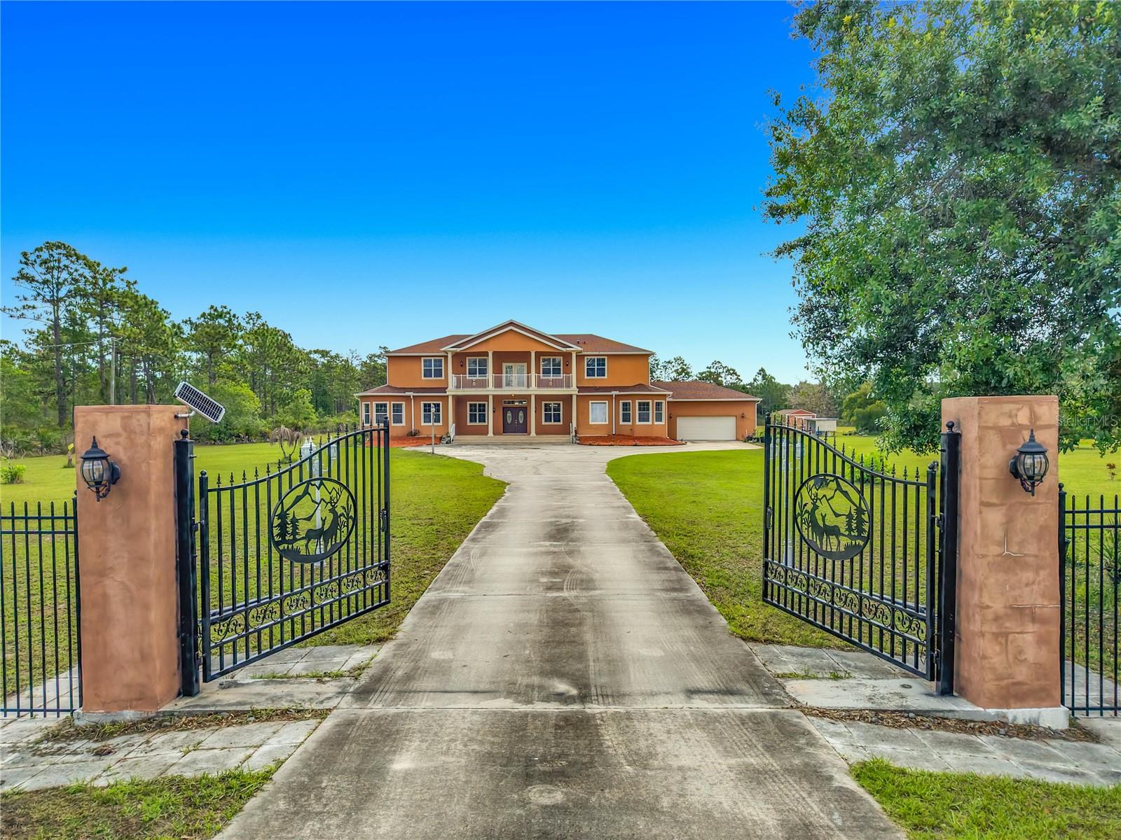 Virtually Staged. One or more photo(s). Dreams do come true! Welcome to your private slice of paradise in Wedgefield! This impressive custom-built estate includes over 5,000 square feet of living space with 6 bedrooms and 6 bathrooms, beautifully set on 4.77 acres and zoned A-2, so you can bring your horses, goats, chickens and more. Built in 2004 and well-maintained, this property blends peaceful country living with modern convenience and community amenities, including an 18-hole golf course, playgrounds, sports courts and nearby Hal Scott Preserve for hiking, biking and nature lovers. A 5-foot wrought iron fence spans the 360-foot front yard with a 20-foot wrought iron electric gate and pedestrian gates on either side, while the rest of the property is enclosed with 5-foot wire fencing - animals and added privacy. The enormous front and back yards for play, gardening, entertaining and enjoying the quiet setting, and the 288 sq. ft. Tuff Shed provides excellent additional storage. Step up to the Shark Coating front porch and through the double-door entry into a grand foyer that sets the tone for the rest of the home. Gorgeous inlaid porcelain tile flows throughout the first-floor living areas, and arched vaulted ceilings add volume and elegance. To one side of the foyer is a welcoming sitting room, and to the other, a formal dining area ready for large gatherings. The spacious, open kitchen anchors the main level with granite countertops, a granite breakfast bar, recessed lighting, abundant cabinetry and a huge walk-in pantry. The open concept layout connects all the spaces, giving you endless options for arranging living, dining and entertaining spaces to suit your lifestyle. On one side of the main floor you will find a guest bedroom with its own private bathroom featuring a Jacuzzi tub with shower - great for visiting guests or multi-generational living. The opposite side of the home hosts two individual office spaces, each with its own exterior entrance and one with a half bath, creating a setup for remote work, home-based business, studio or hobby spaces. The main floor primary suite is a true retreat, complete with a tranquil sitting area and separate dual walk-in closets. The expansive primary bath includes a glass-enclosed shower, luxurious Jacuzzi garden tub and dual vanities, giving you a spa-like experience at home. French doors from the main living area open out to an approximately 1,100 sq. ft. screened lanai with porcelain tile flooring and a peaceful forest view. This impressive outdoor living area includes counter space with cabinets, a sink and a convenient half bath - for hosting parties, enjoying quiet mornings with coffee, or relaxing after a long day without ever leaving your property. Up the grand curved staircase, a loft area opens to a balcony overlooking the front yard, giving you yet another beautiful space to relax or gather. Four additional bedrooms extend off the loft, two on each side, and each pair of bedrooms is served by a bathroom with a Jacuzzi tub and shower. One of the upstairs bedrooms features its own private sunroom, adding even more flexible living space for a reading nook, playroom, workout area or creative studio. This home is truly impressive - space, serenity and versatility inside and out! Come experience the peaceful setting and spectacular location for yourself.