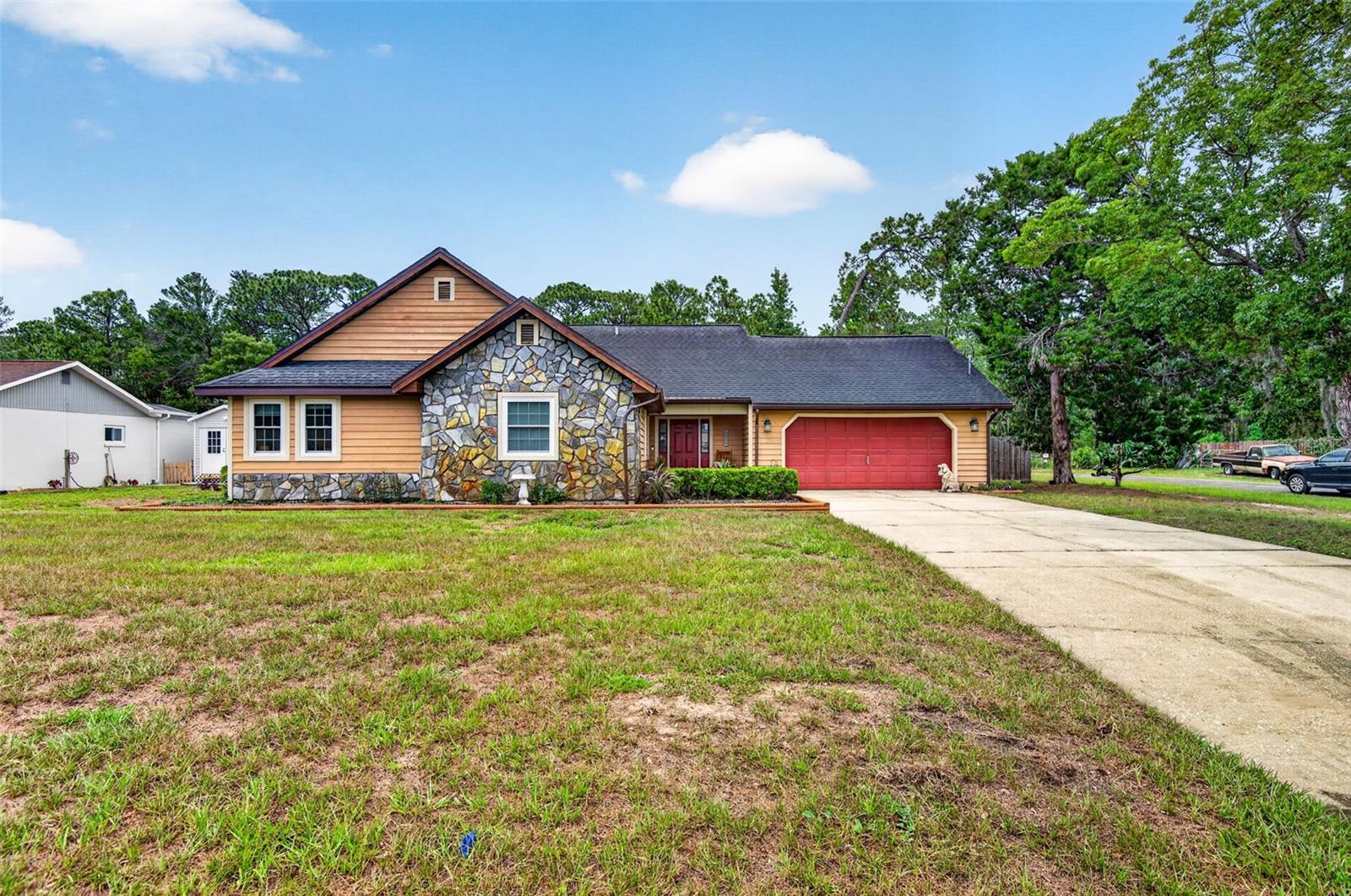 Welcome home to this charming 3-bedroom, 2-bath residence perfectly situated on approximately 1/3 of an acre on a spacious corner lot. Backing directly to the Boy Scout Reserve, you'll enjoy exceptional privacy, tranquil wooded views, and frequent visits from deer, birds, and other native wildlife—all from the comfort of your own backyard.Inside, you'll find a warm and inviting layout featuring a spacious kitchen with ample cabinetry, large wraparound breakfast bar provides abundant prep space and seating, and an adjoining dining area that overlooks the backyard. The impressive living room boasts soaring tongue-and-grove wood plank vaulted ceilings and a beautiful floor-to-ceiling stone fireplace, complete with a wood-burning stove, creating the perfect gathering space for family and friends. Sliding glass doors lead to the screened lanai, with its vaulted wood ceilings creating a warm, rustic atmosphere providing the ideal spot to relax while taking in the peaceful surroundings.Step outside to the spacious backyard, and you’ll appreciate views of the raised garden beds, mature trees, and your very own chicken coop—ideal for those seeking a homesteading lifestyle or simply fresh eggs and homegrown produce. Whether you’re enjoying your morning coffee, entertaining guests, or unwinding at the end of the day, this peaceful outdoor retreat offers the perfect blend of comfort, privacy, and country charm.Major updates provide peace of mind, including:New A/C (2022)Enhanced nitrogen-reducing septic system (2023)New water heater (2025)New water softener (2025)If you've been searching for a home that combines comfort, character, and a connection to nature, this one is a must-see. Enjoy the serenity of country living while still being conveniently located near shopping, dining, and everyday conveniences.