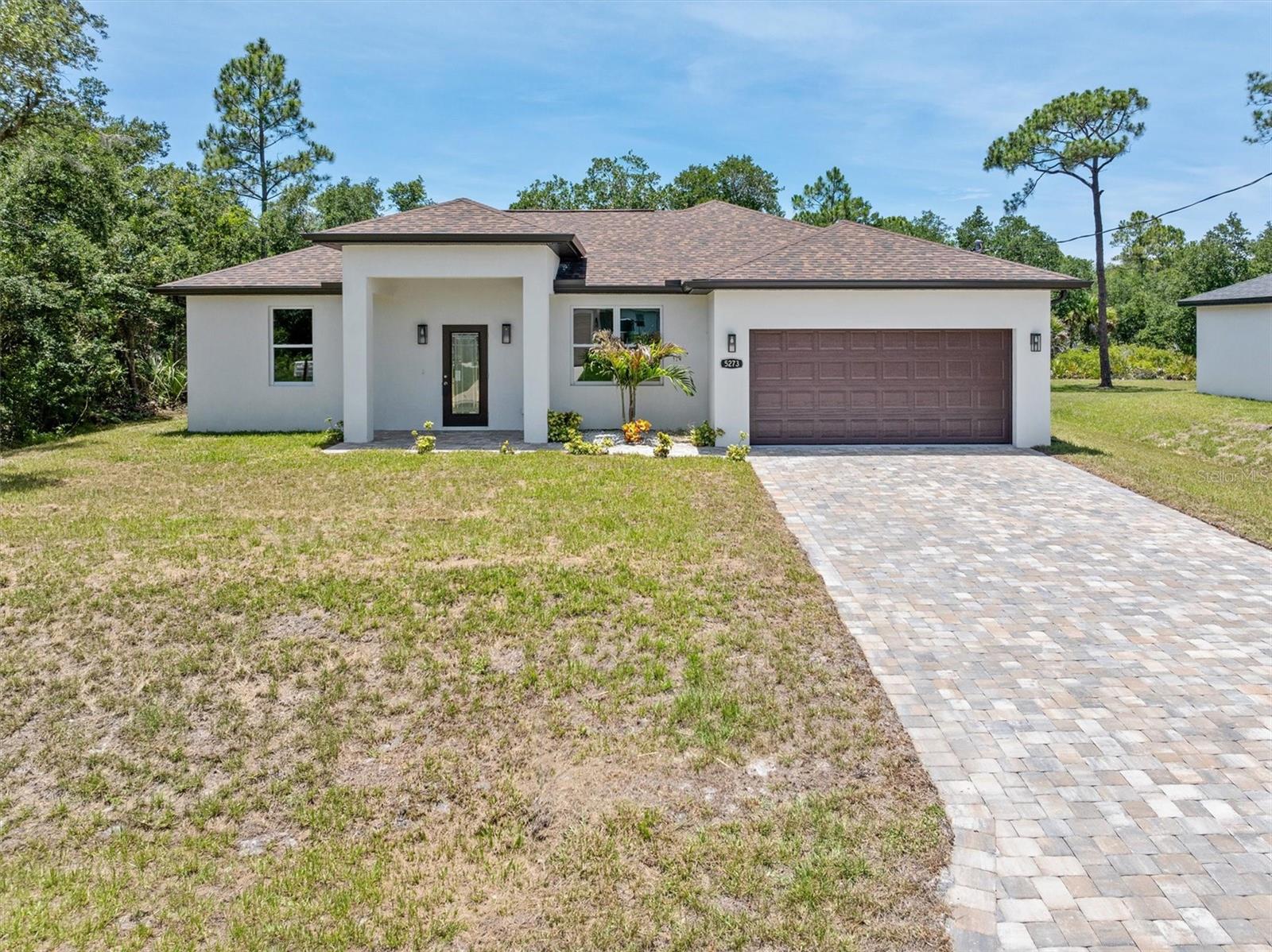 Brand New 2025 Home in North Port, FL! Welcome to this beautifully crafted 3-bedroom, 2-bath home with a 2-car garage, perfectly located in the heart of North Port. Built with both style and durability in mind, this home features hurricane-impact windows and doors, providing added protection, energy efficiency, and peace of mind year-round. Step inside and be greeted by soaring 9-foot ceilings accented by tray-lighted and coffered ceiling details in both the living room and primary suite—an impressive feature often found in much more expensive homes. Natural light pours through the impact windows and doors, creating a bright and inviting atmosphere throughout. The kitchen is designed to impress with a complete stainless steel appliance package, trash compactor, 42-inch upper cabinets with crown molding, granite countertops and windowsills, recessed lighting, and a large center island that provides plenty of space for cooking, gathering, and entertaining. The dining room offers sliding glass doors that lead directly to the screened lanai, making indoor and outdoor living easy and enjoyable. The entire home features tile flooring throughout, creating a clean, modern look that is both attractive and easy to maintain. Upgraded crown molding and trim add a refined touch to every room. The spacious primary suite is a relaxing retreat with its tray-lighted and coffered ceiling, ceiling fan, and private sliding door access to the screened lanai. The primary bathroom includes a beautifully tiled walk-in shower. Guest bedrooms offer generous built-in closet space, while the guest bathroom features a tub and shower combination with tiled walls for added style and convenience. The laundry room is thoughtfully equipped with shelving and a utility sink to help keep daily tasks organized. Enjoy the Florida lifestyle from the comfort of your screened-in lanai, the perfect place to unwind, enjoy a morning coffee, or entertain guests throughout the year. Outside, you'll appreciate the fully paved driveway and walkway, along with an automatic garage door opener that adds convenience to everyday living. Every detail has been carefully considered to make this home truly move-in ready. Conveniently located near schools, shopping, dining, and everyday amenities, this North Port home offers comfort, quality, and modern design in an excellent location. Call today to schedule your private showing!